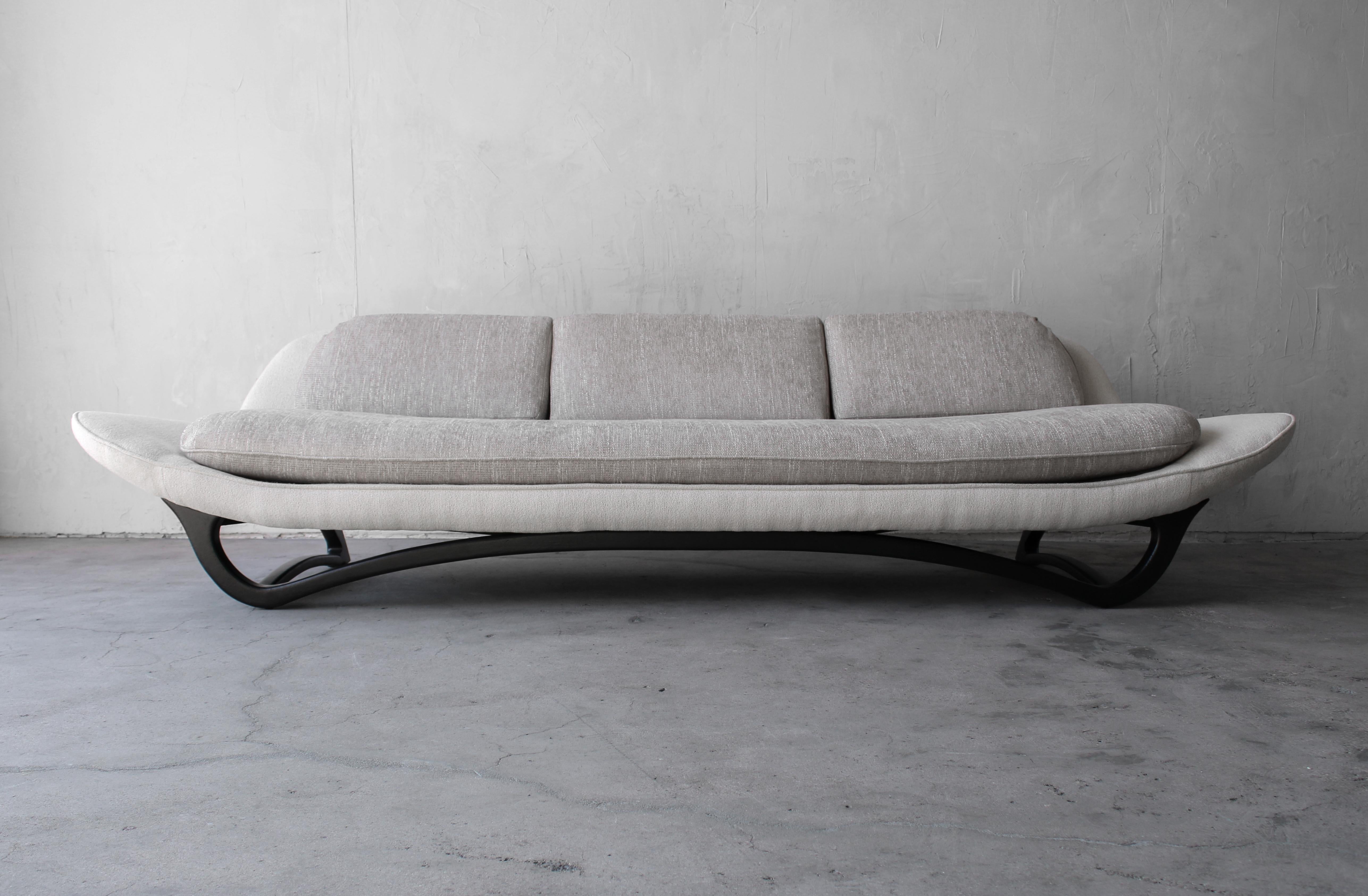 A classic, true 1960's, mid-century gondola sofa. Amazing lines and details make it a real show stopper. It measures 9ft in length and is supported by a perfectly sculpted base. A true classic sofa that has been updated for todays modern