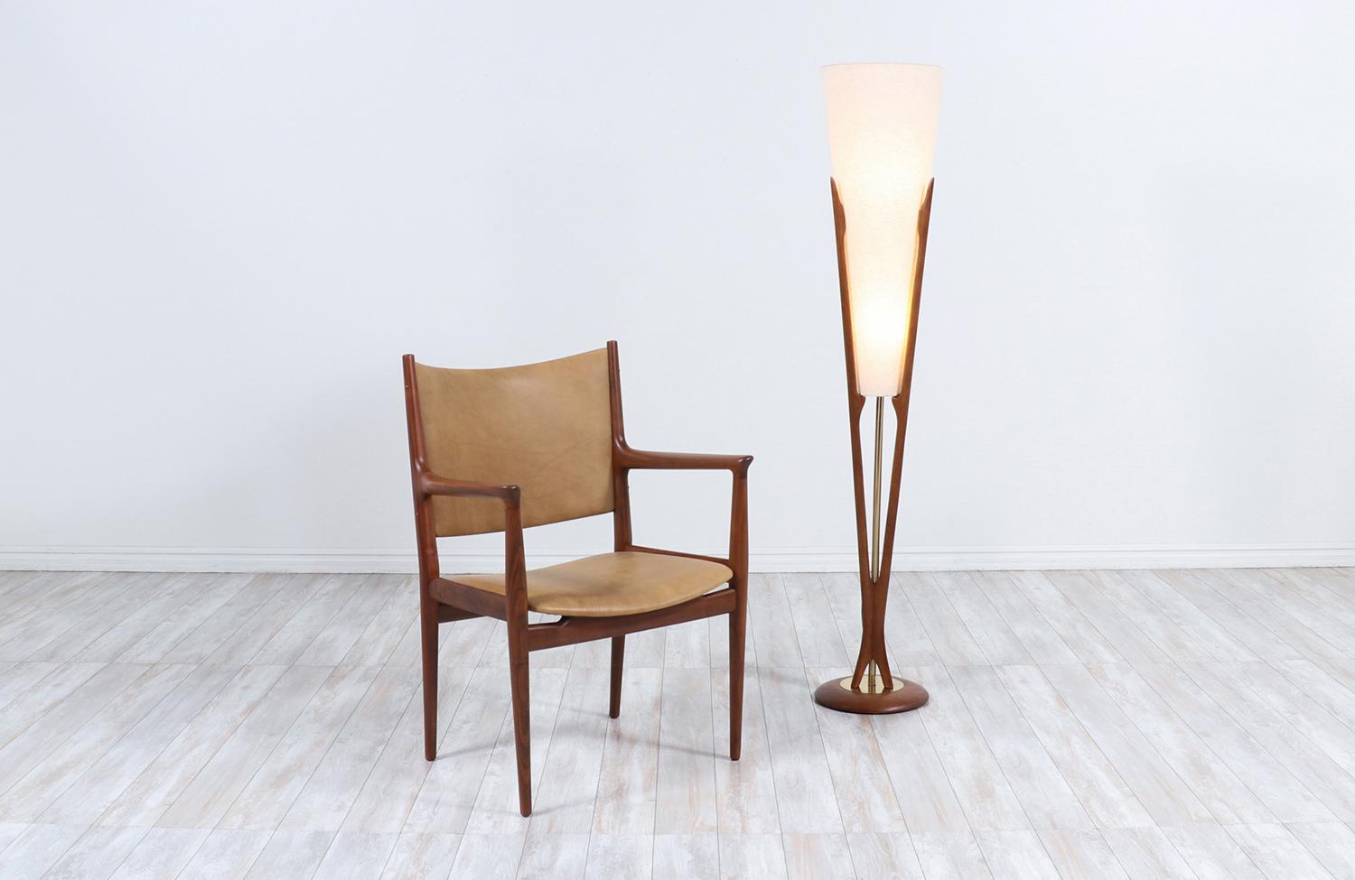 Stunning sculpted modern floor lamp designed by John Keal and manufactured by Modeline of California in the United States circa 1960s. This rare floor lamp is comprised of a carved walnut wood frame that connects from the top to the rounded base