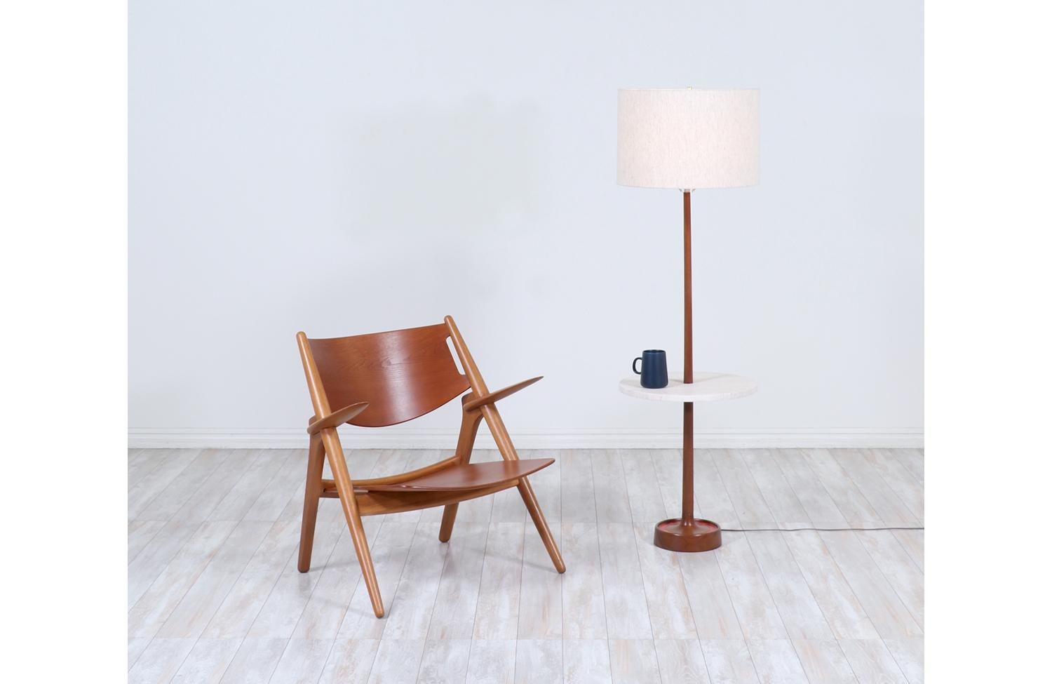 Moderne Stehlampe, entworfen und hergestellt von Laurel Lamp Co. in den Vereinigten Staaten, ca. 1960er Jahre. Dieses schlichte, minimalistische Design besteht aus einem hohen Walnussholzkorpus mit einer runden Schiefertischplatte aus Travertinstein