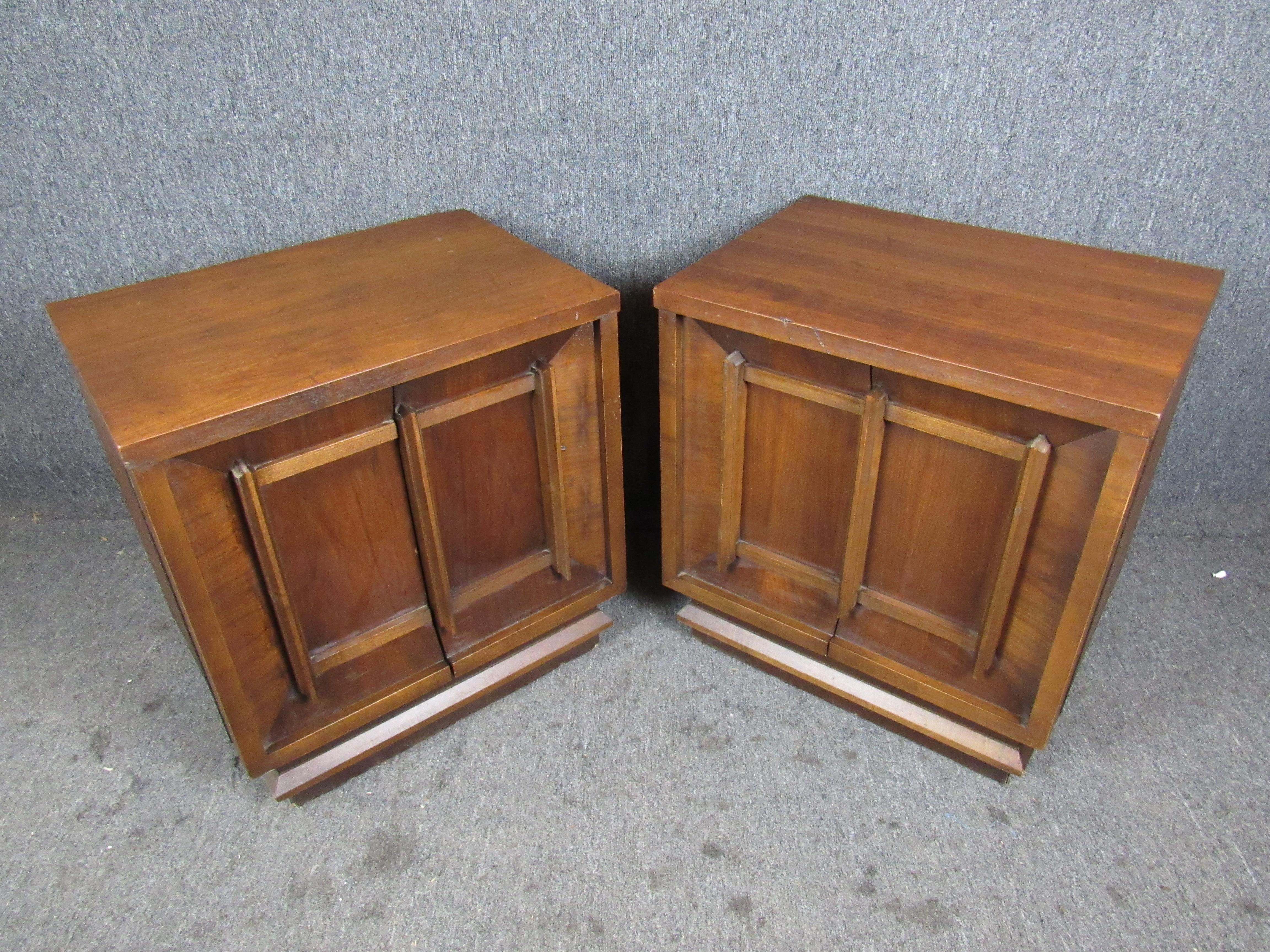 Fantastic pair of substantial vintage walnut nightstands with elegant sculpted doors. Blending brutalist and Asian design influences, this simple yet timeless design is sure to fit in seamlessly with a wide variety of decors- whether in the home or
