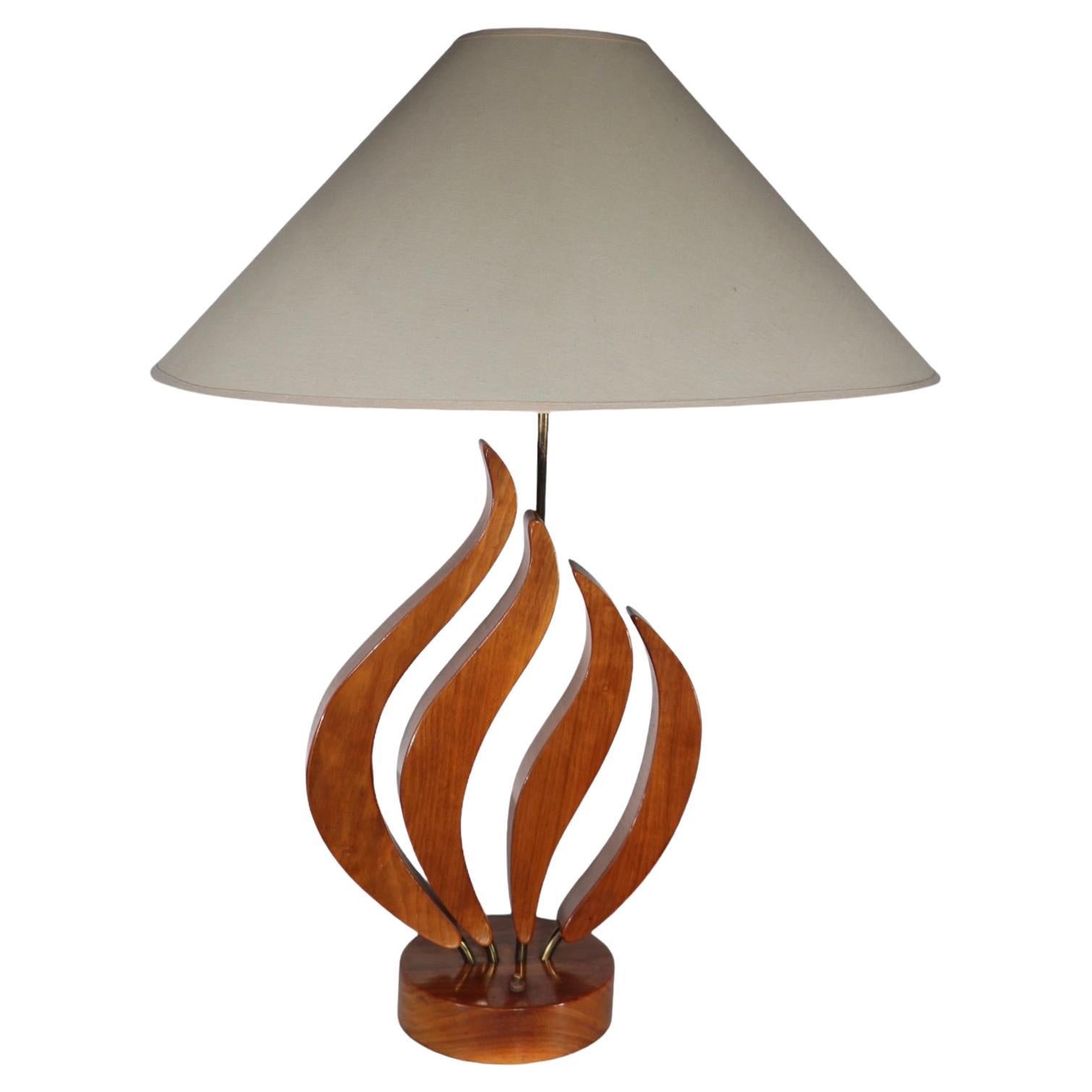 Unusual organic form Mid Century table lamp, having four pedal like wood elements sprouting from a circular plinth base, all constructed of solid wood. Design reminiscent of the lamp designs of Adrian Pearsall, and John Keal, however we cannot