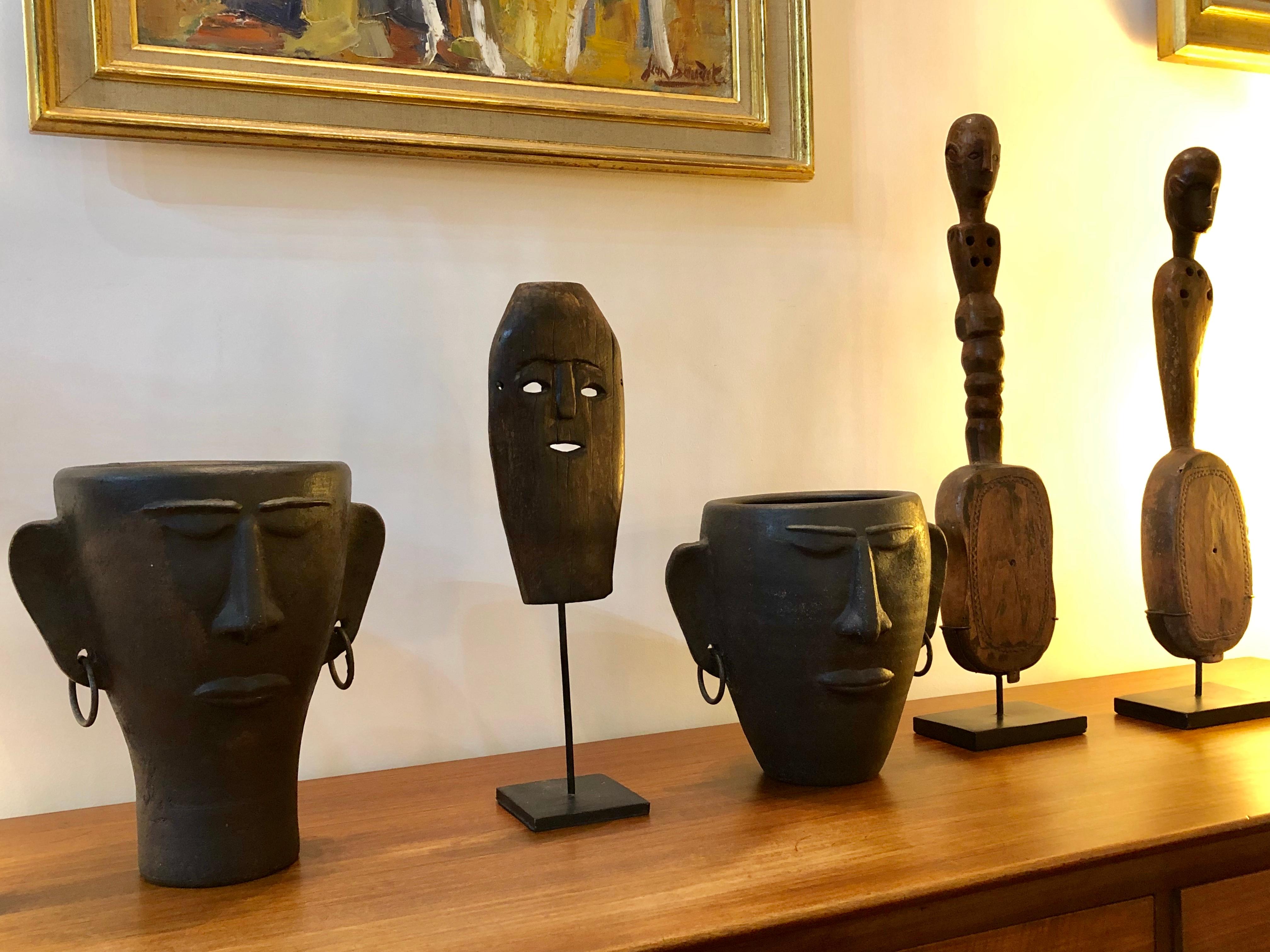 Timor Island sculpted wooden traditional mask (early 20th century) on contemporary metal stand. This is a traditional mask of a figure with male facial features and two holes as eyes and another for the mouth. The island of Timor gave rise to a