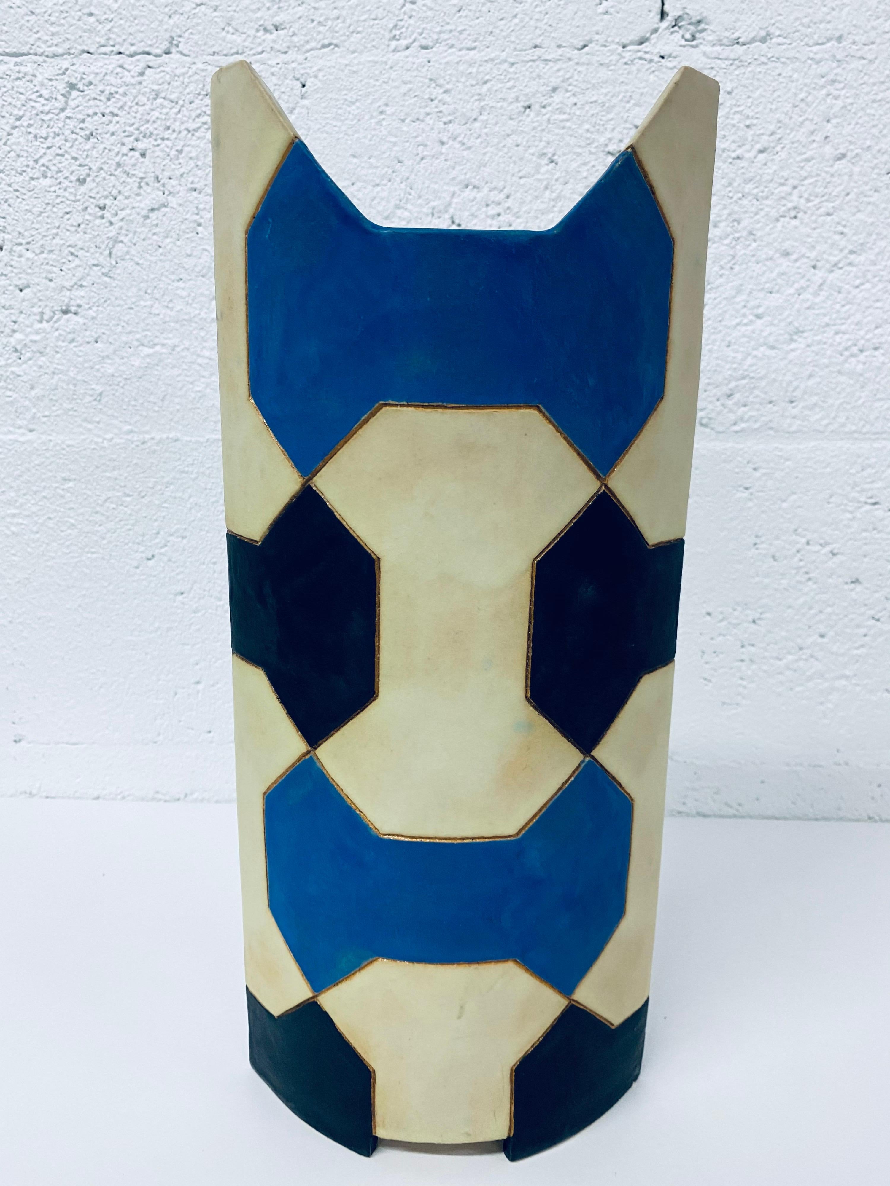 Sculpted vase with geometric blue, black and cream colored patters; signed by artist.