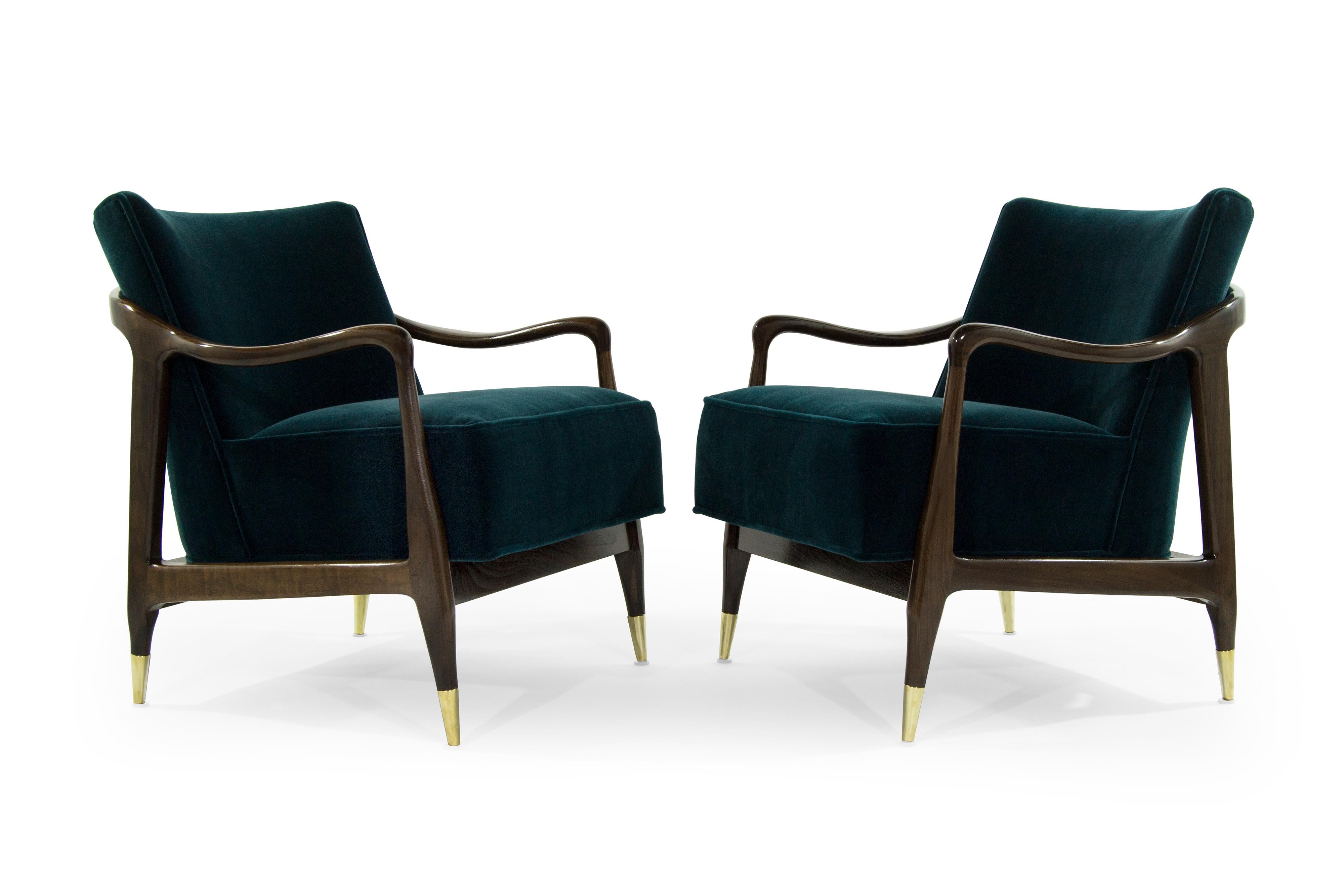 Exquisite pair of Mid-Century Modern lounge chairs featuring sculptural walnut frames, which have been expertly restored to their original integrity. They boast handcut high grade foam, as well as hand polished brass sabots.
They have been recovered