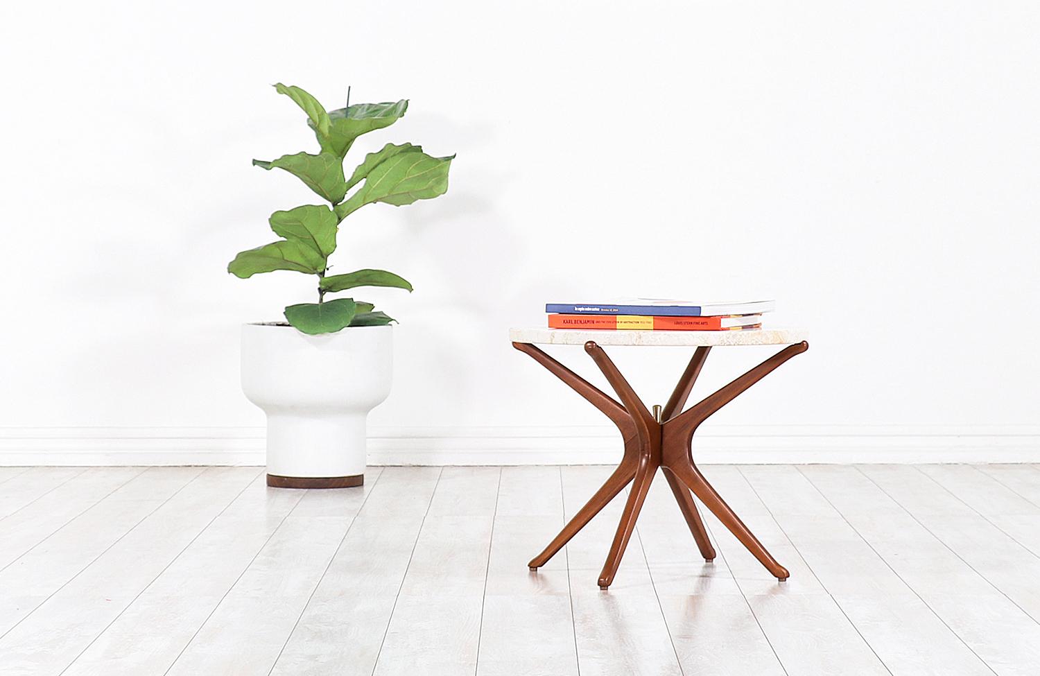 Stylish Mid-Century Modern sculpted Jax side table designed and manufactured in Italy circa 1950s. This sleek design features an atomic Jax-shaped walnut wood base with a brass pin in the center of the structure, adding an elegant touch to the