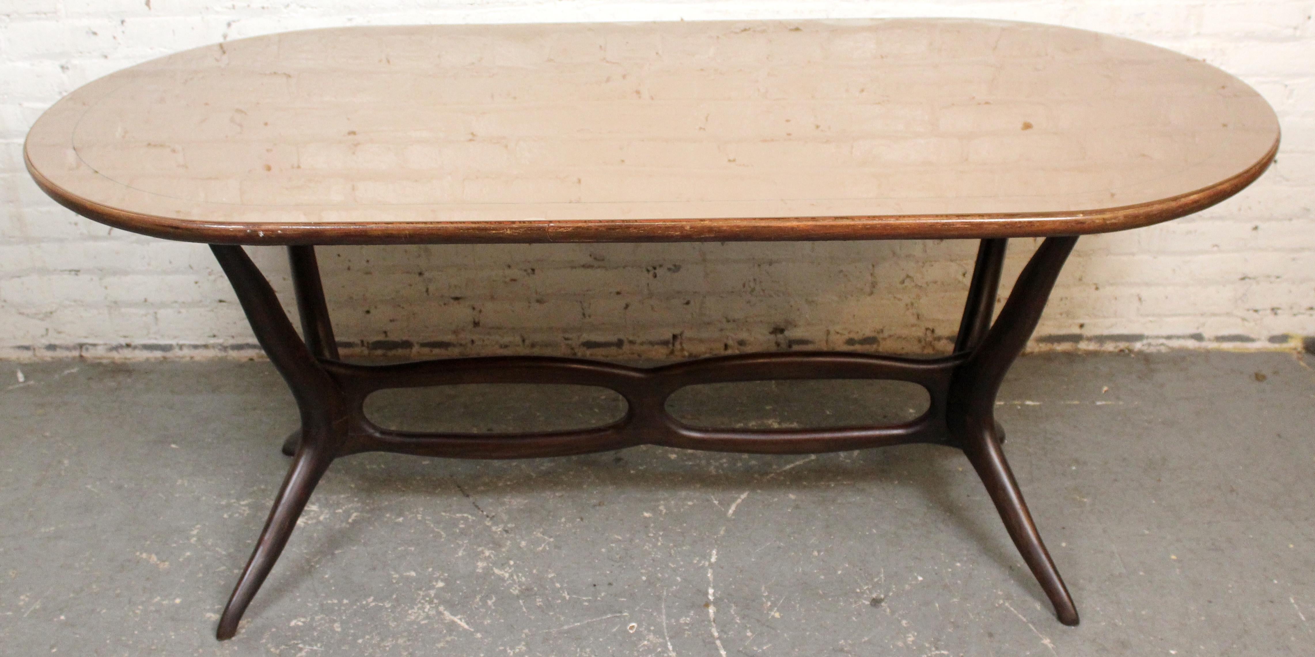 Bring home the timeless luxury of genuine mid-century Italian design with this exquisite hand-crafted dining table signed by Luigi Dotti of Pontenure in Piacenza, Italy. Proudly boasting a unique ornate base with expertly carved solid mahogany
