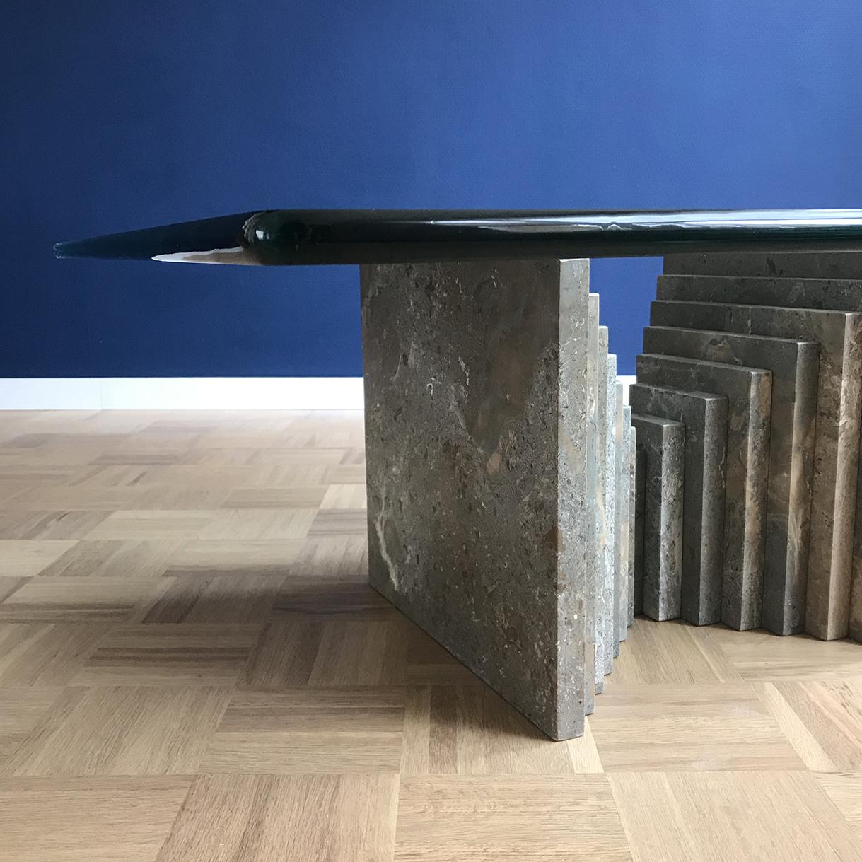 Esta mesa de centro está anclada por dos robustos y esculturales bloques de mármol. Con texturas crudas y sutiles matices tonales, los bloques de mármol recuerdan la icónica estética Brutalista. Los matices grises del mármol exhiben una gama de