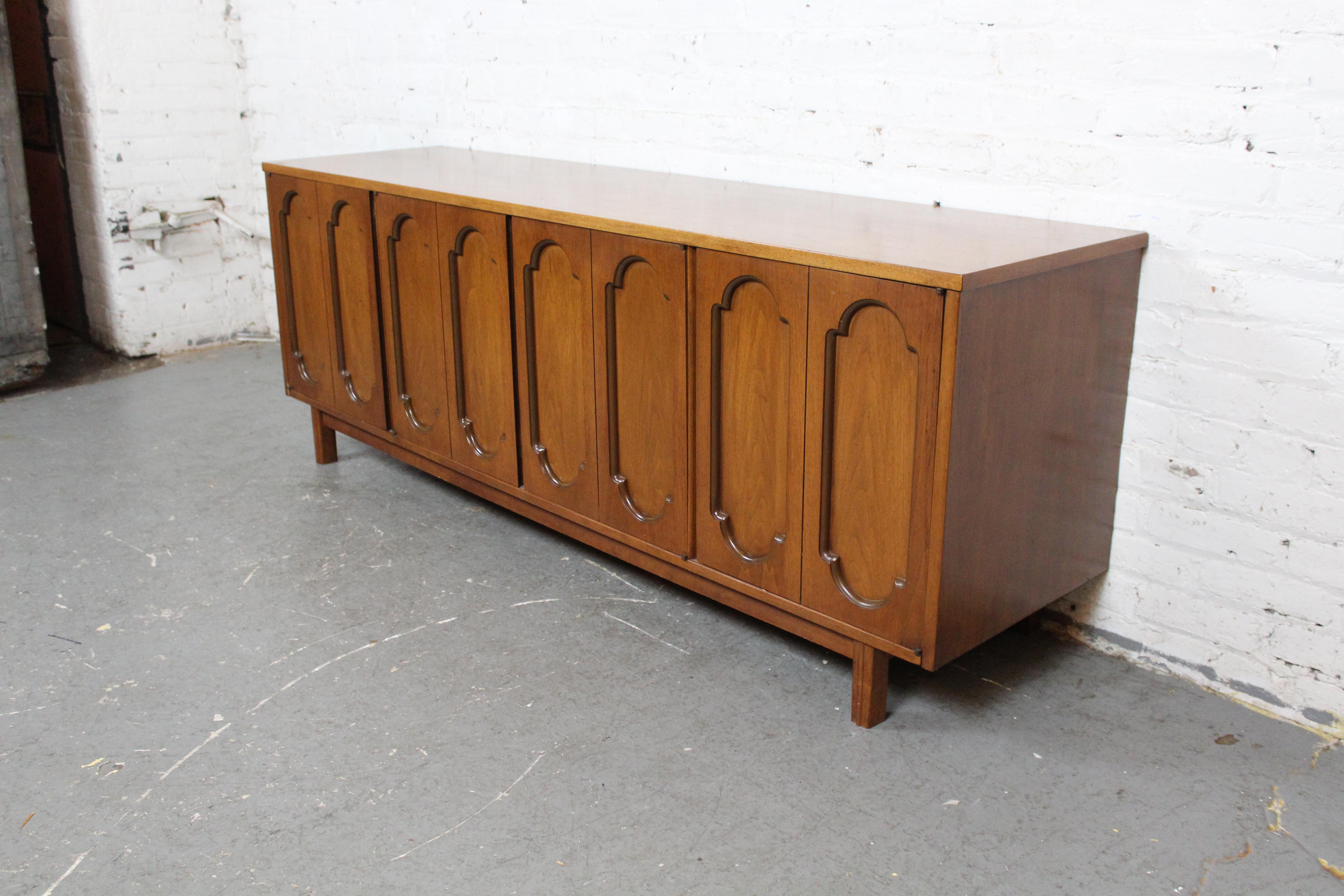 Ajoutez une touche aérienne à n'importe quelle pièce avec ce magnifique buffet vintage fabriqué par Dixie Vintage, à Lexington, en Caroline du Nord. Dotée de quatre portes à l'élégant motif de vitres sculptées, la pièce s'ouvre pour révéler de