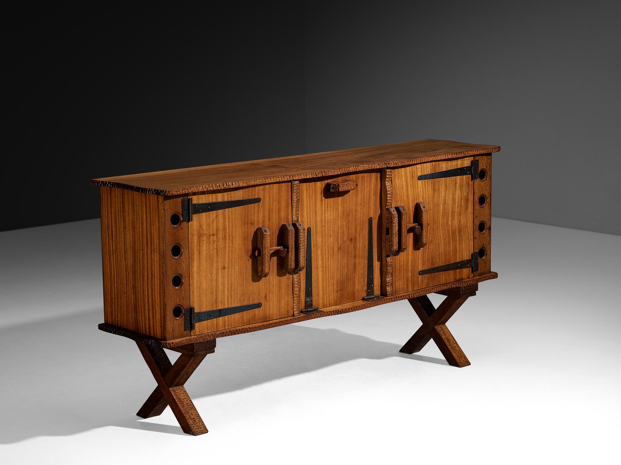 Credenza, meranti, mogano, ferro battuto, Europa, anni '60

Questa credenza, risalente agli anni '60, si distingue immediatamente per la sua forma insolita e il robusto contrasto di materiali. Il corpo del pezzo è parzialmente costruito in meranti,