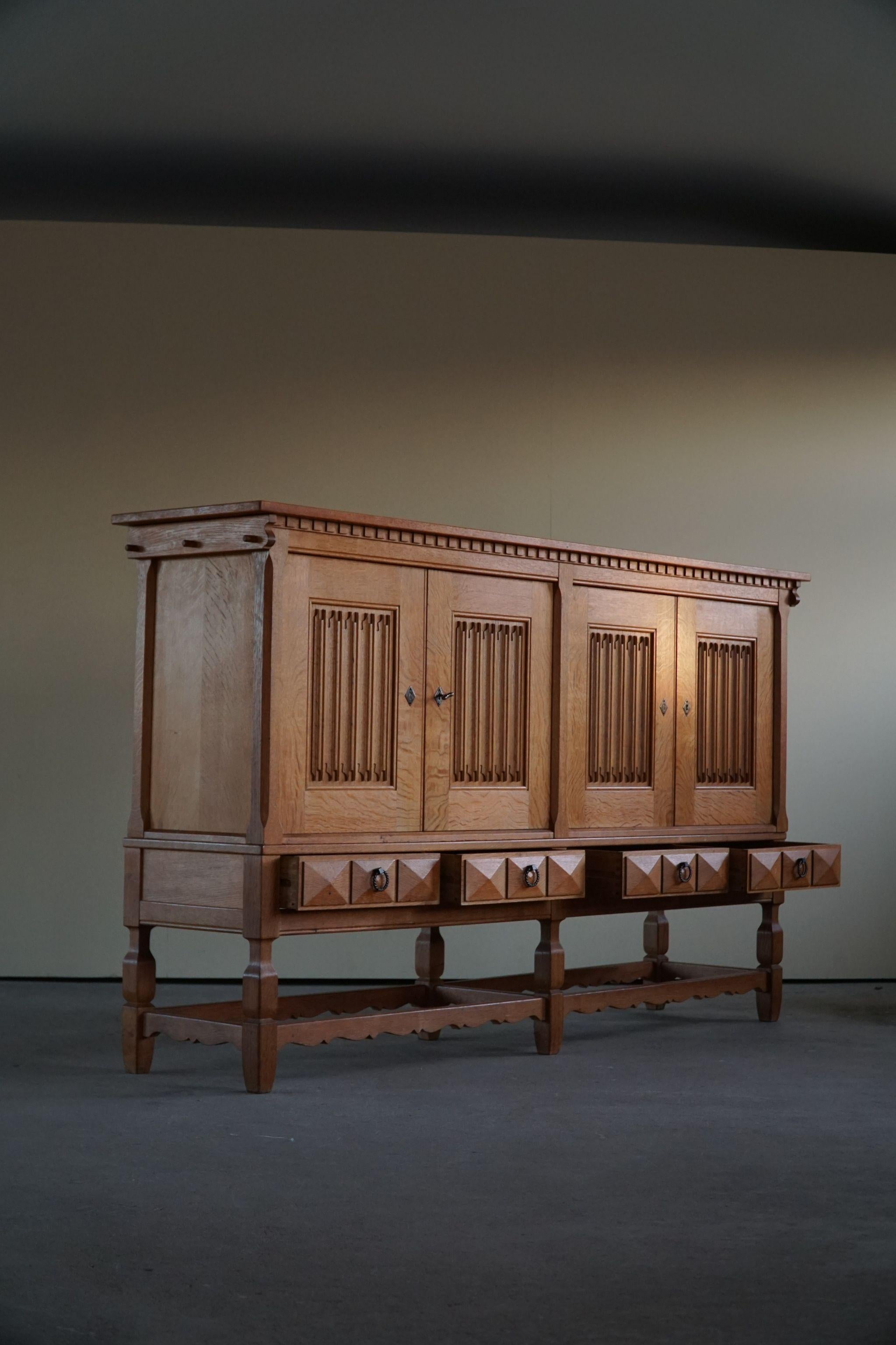 Großes rechteckiges brutalistisches Sideboard aus massiver Eiche mit Messinggriffen. Hergestellt von einem dänischen Möbelschreiner in den 1950er Jahren. Schöne skulpturale Frontgestaltung und schöne warme Patina.
Dieses Stück ist in einem sehr