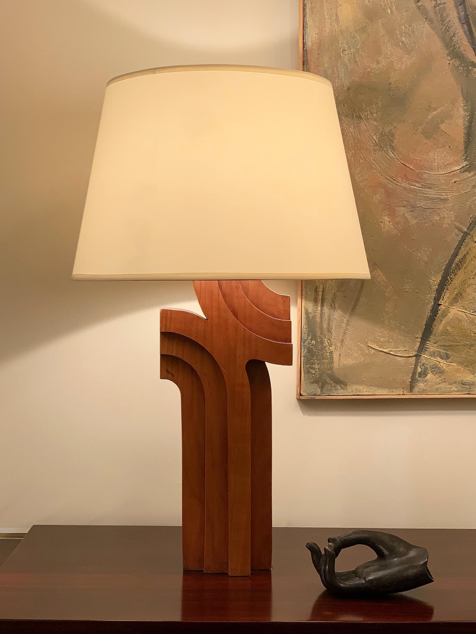A carved wood sculptural table lamp.
France, circa 1970.
Measures: With the shade: 66 cm tall by 41 cm diameter.
Lamp base only: 47 cm tall by 18 cm wide.