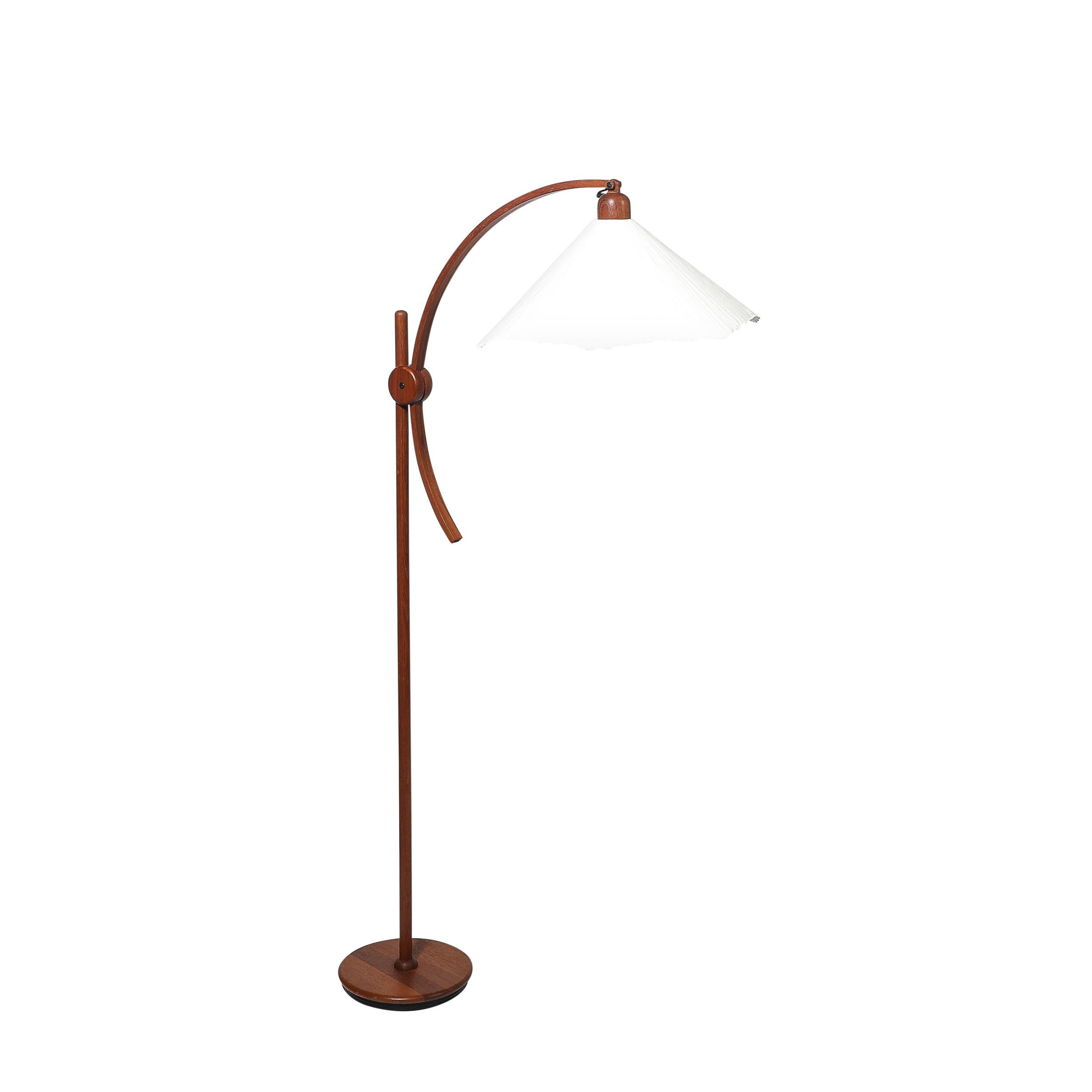 Questa lampada da terra regolabile Mid-Century Modern, progettata e realizzata in Francia intorno al 1960, è un'unione magistrale di eleganza scultorea e design funzionale. L'uso del legno di teak e di un paralume in carta d'archivio personalizzato