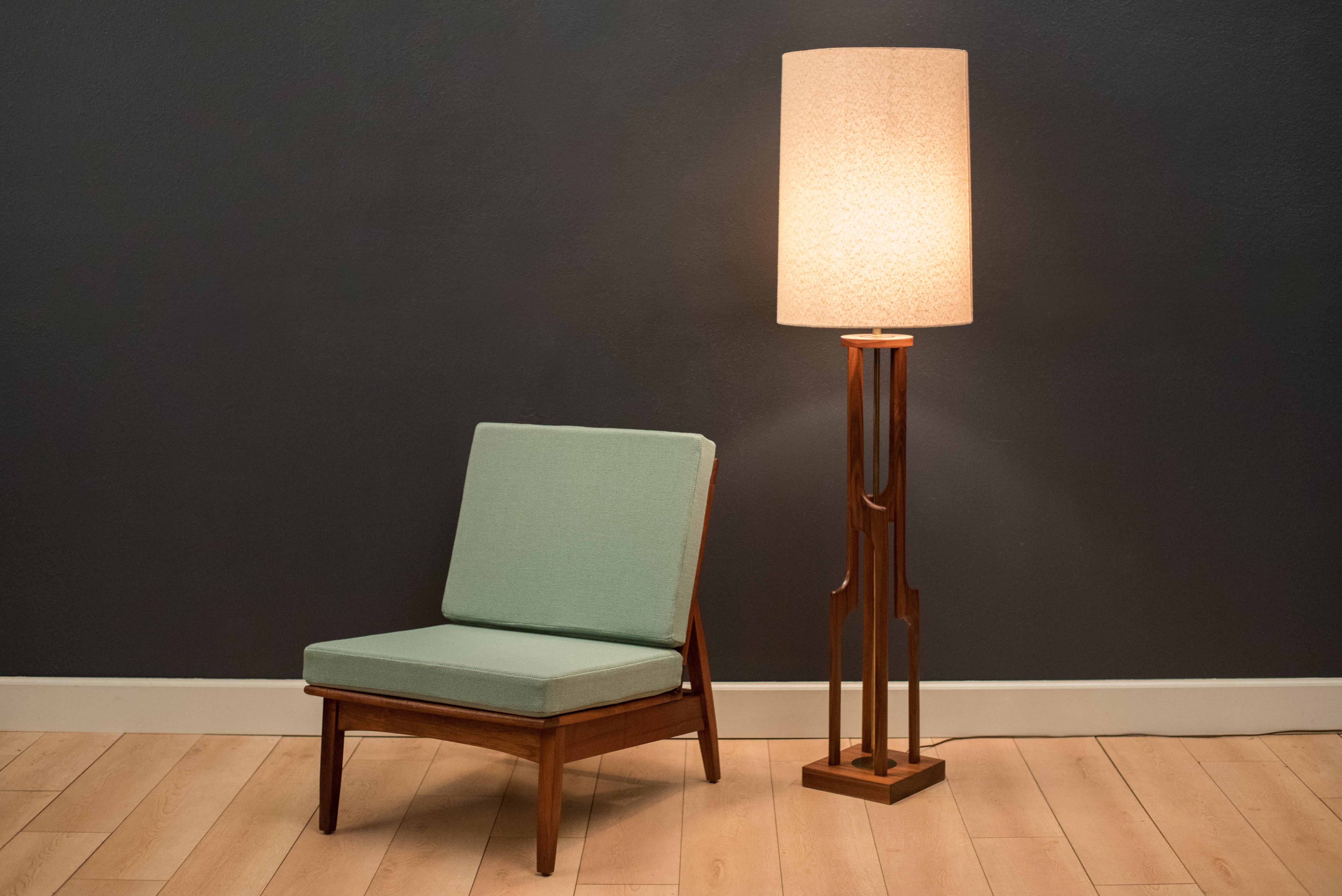 Mid-Century Modern floor lamp by Modeline, circa 1960s. This piece displays well from any angle and features a sculptural walnut base and brass accents. Original drum shade included.