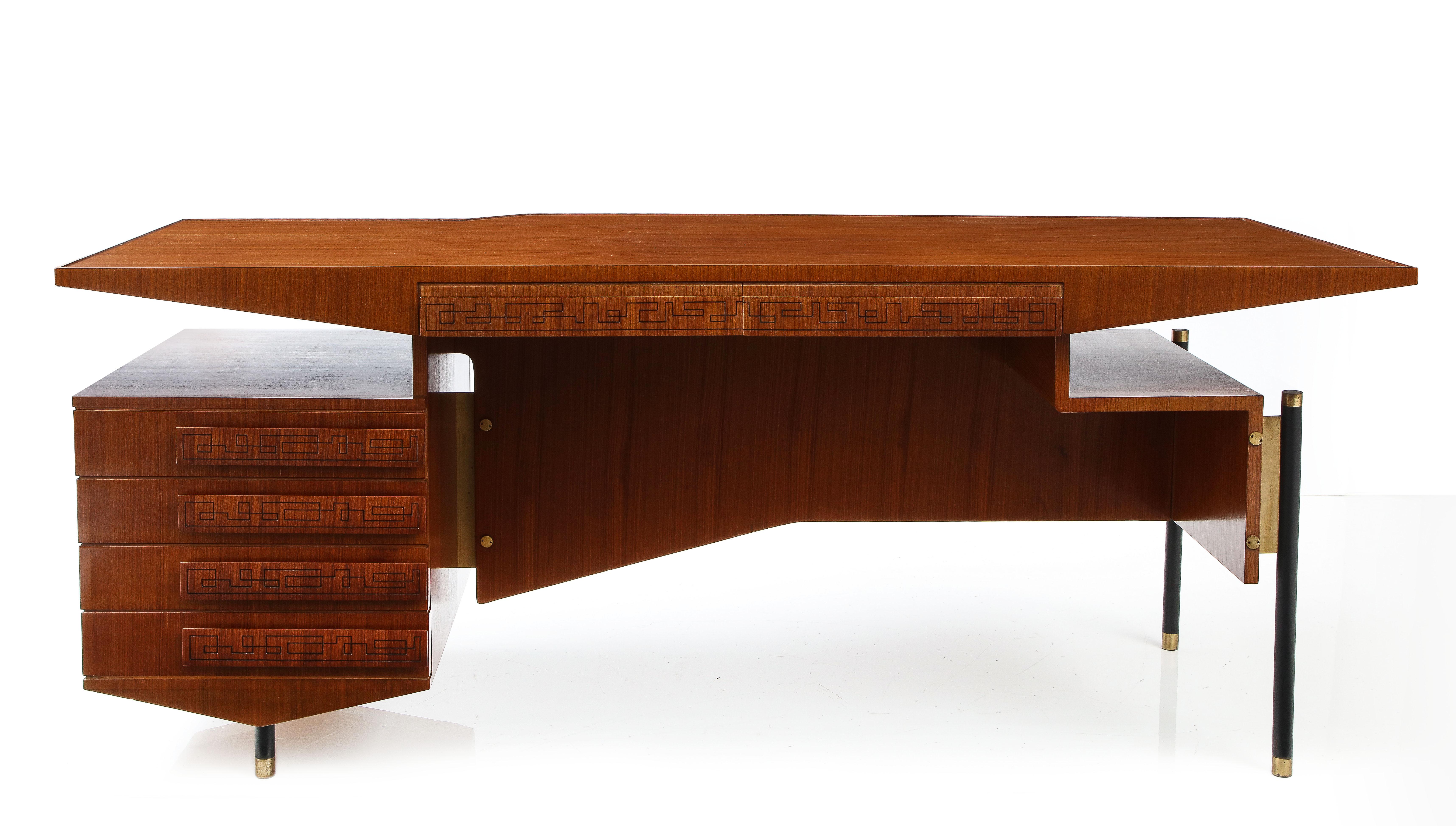 Impressive, striking desk in the style of Ico Parisi. Beautiful Grecian details carved into the walnut of the drawers, with smart steel legs capped with brass feet.