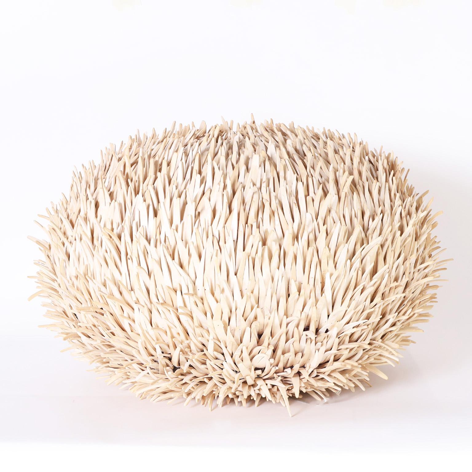 Striking sea urchin form table lamp ambitiously crafted with hundreds of bleached coconut husk spines fixed to a sturdy metal frame.