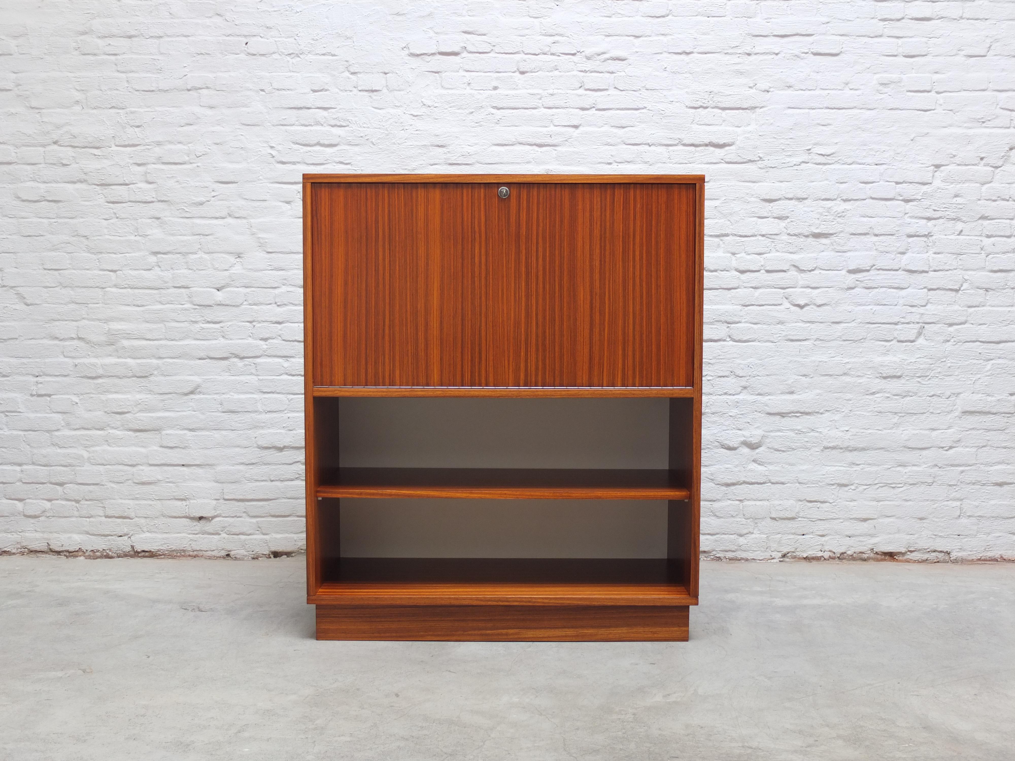 Rare secretary cabinet designed by Belgian modernist designer Alfred Hendrickx for Belform, 1960s. Finished in a decorative Zebrano (or Zingana) wood veneer and standing on a rectangular wooden base. In mint restored condition and comes with one