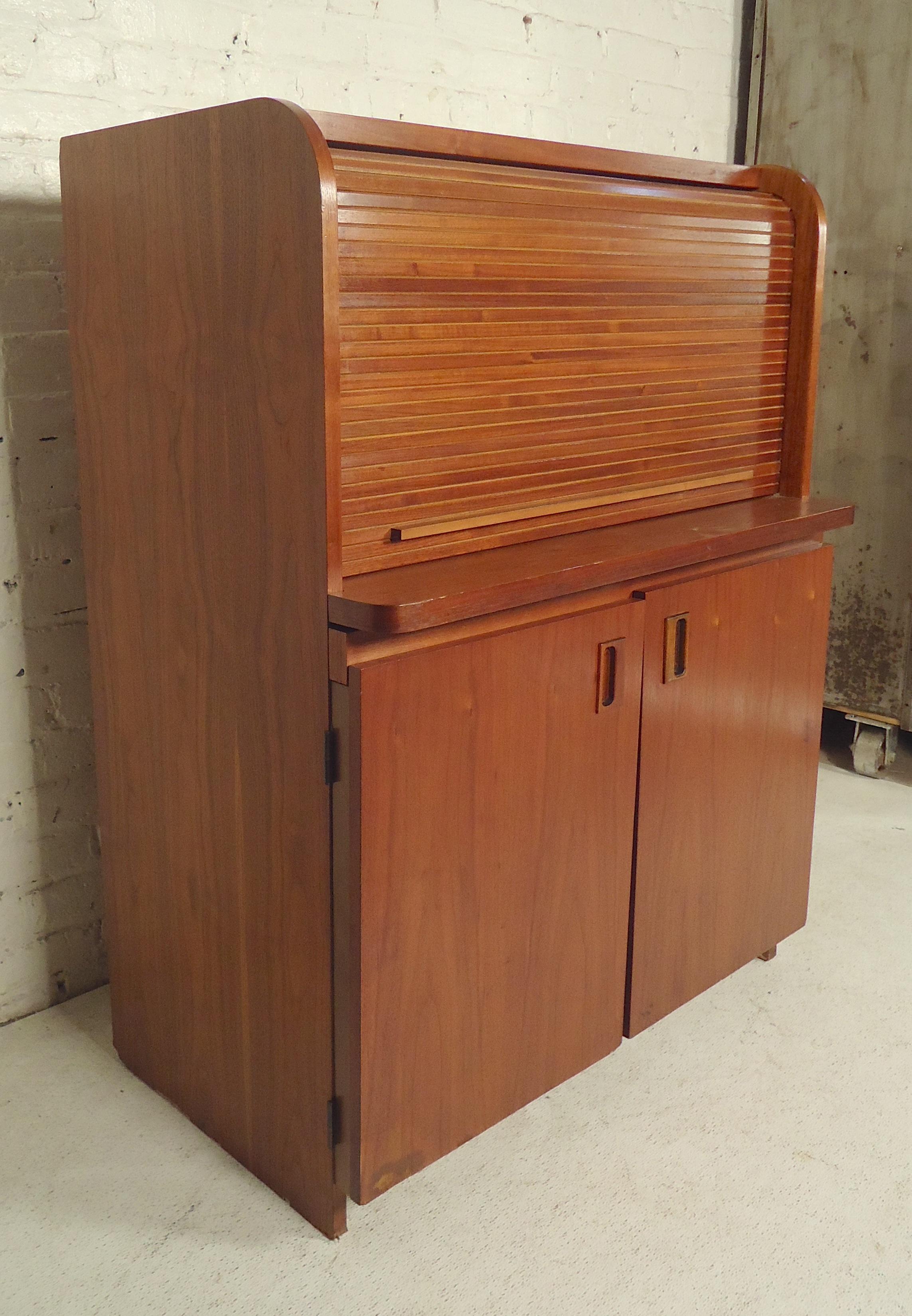 Teak wood cabinet with tambour door top, pull out desk top, and bottom storage space. Great office option for small rooms.

(Please confirm item location, NY or NJ, with dealer).
 