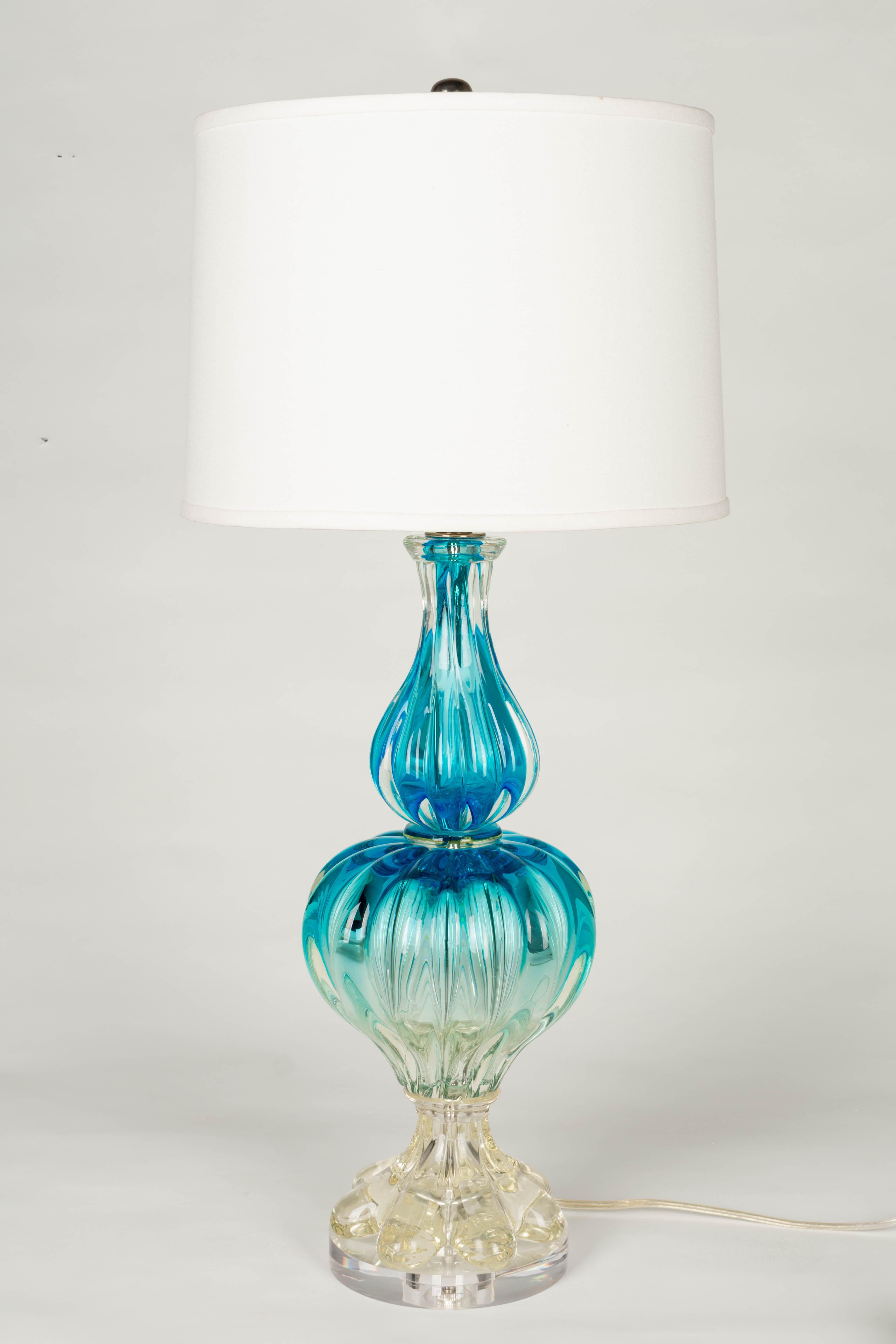 A midcentury Murano glass lamp in beautiful aquamarine color with blue at the top and fading to clear at the bottom. Three heavy, thick ribbed, hand blown glass pieces. New lucite base. Rewired with new socket. Shade is NOT included. 
Dimensions: