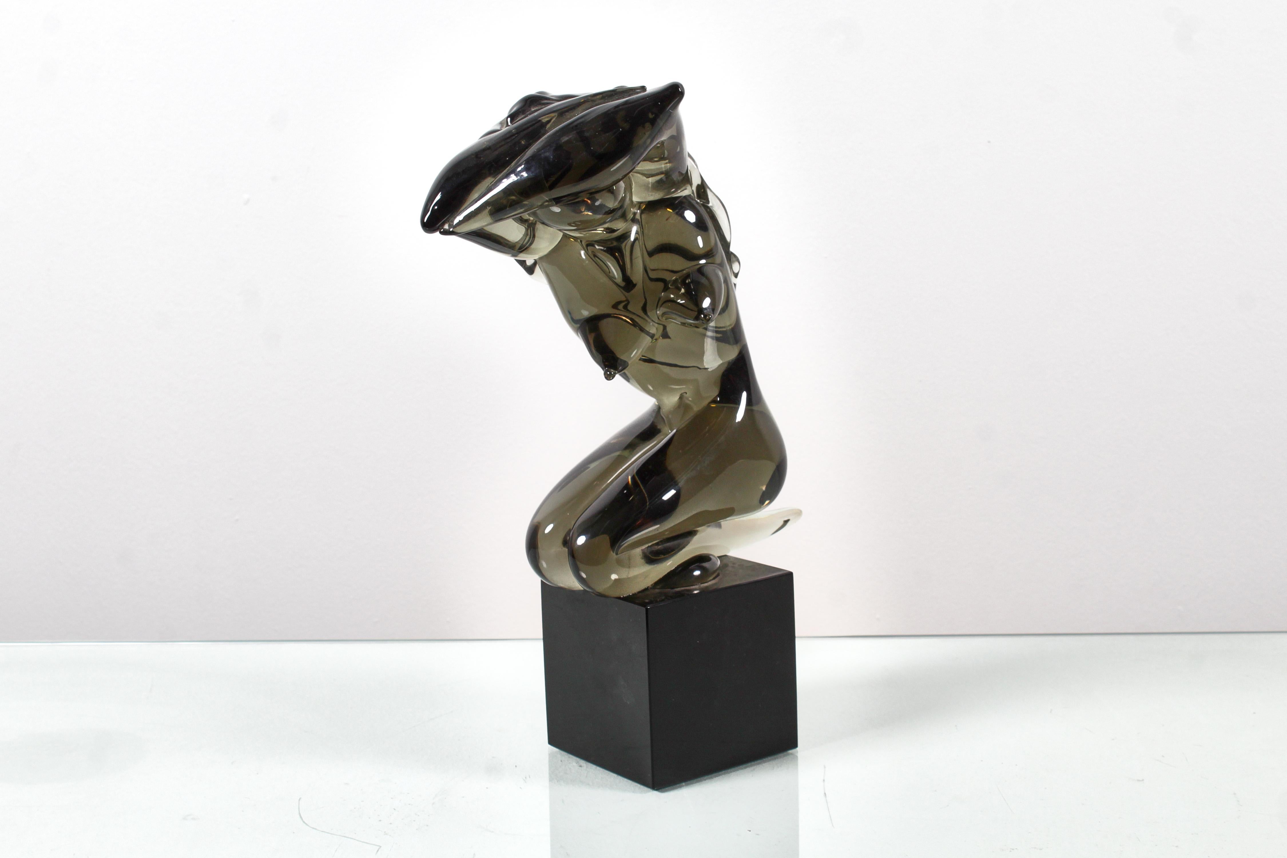 Delightful sculpture depicting a stylized woman's body in smoky green Murano glass on a cubic black glass pedestal. The artwork, created in the 1970s, can be attributed to the Murano manifacturer Seguso.