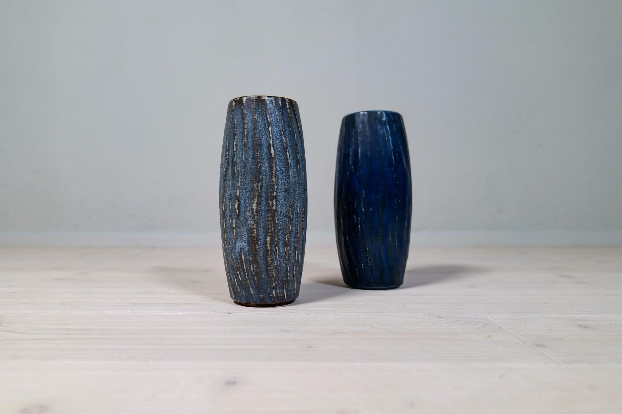 Ces vases en céramique, baptisés Rubus, ont été conçus par l'une des icônes du design céramique en Suède, Gunnar Nylund. Ce set contient 2 pièces aux couleurs et formes bleu terre magnifiques. 

Bon état vintage, avec usure. 

Dimensions : Hauteur