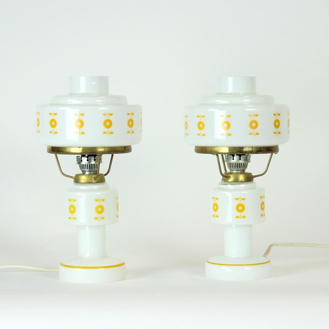 Beautiful set of two table lamps from mid-century era. Produced in 1960s as a set for nightstands. The lamps have a more classical looks of light with the touch of features typical for the design era - like the orange painted details on the shields.