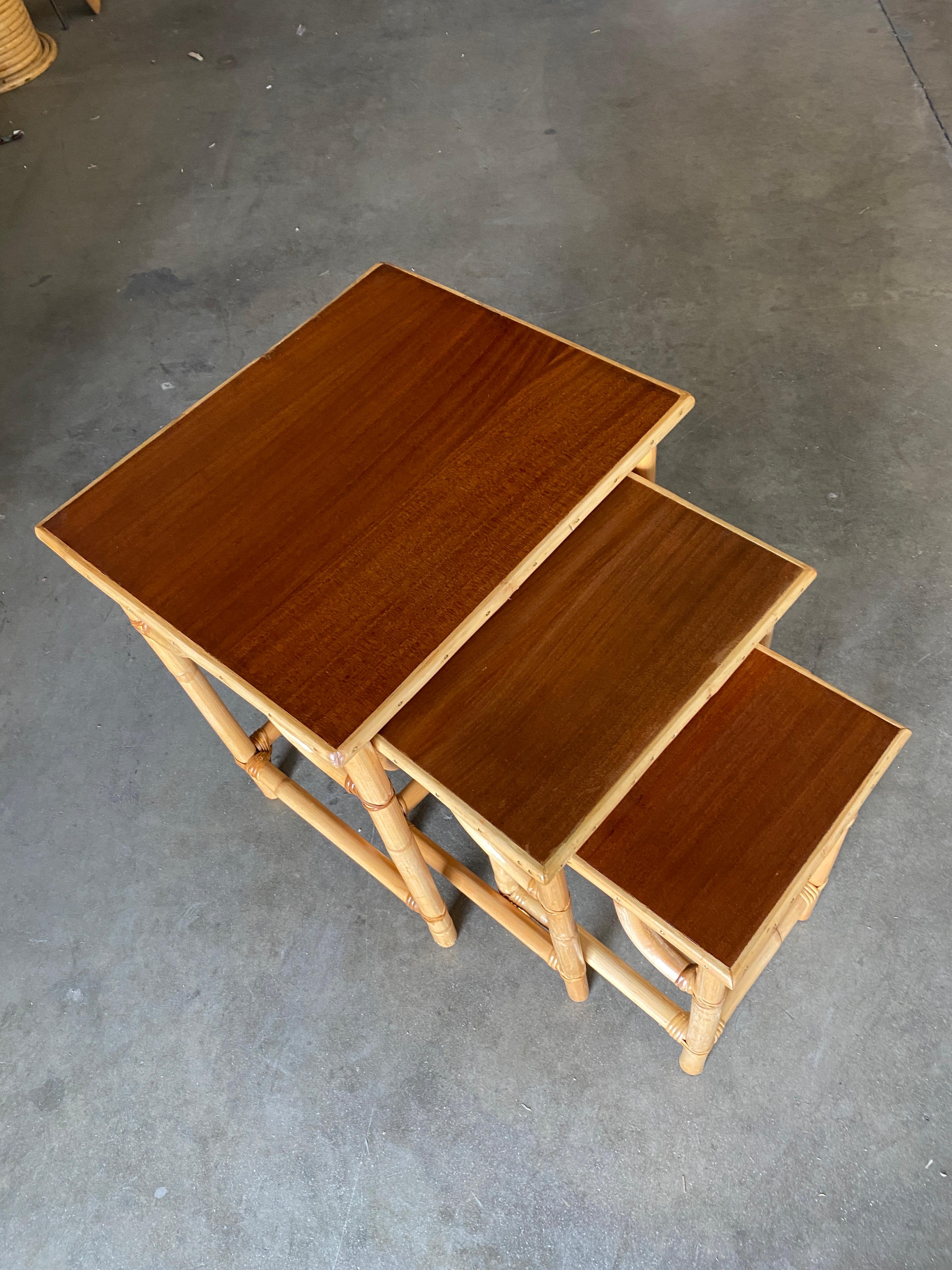 American Restored Mid-Century Set of 3 Rattan Nesting Side Tables with Mahogany Top For Sale