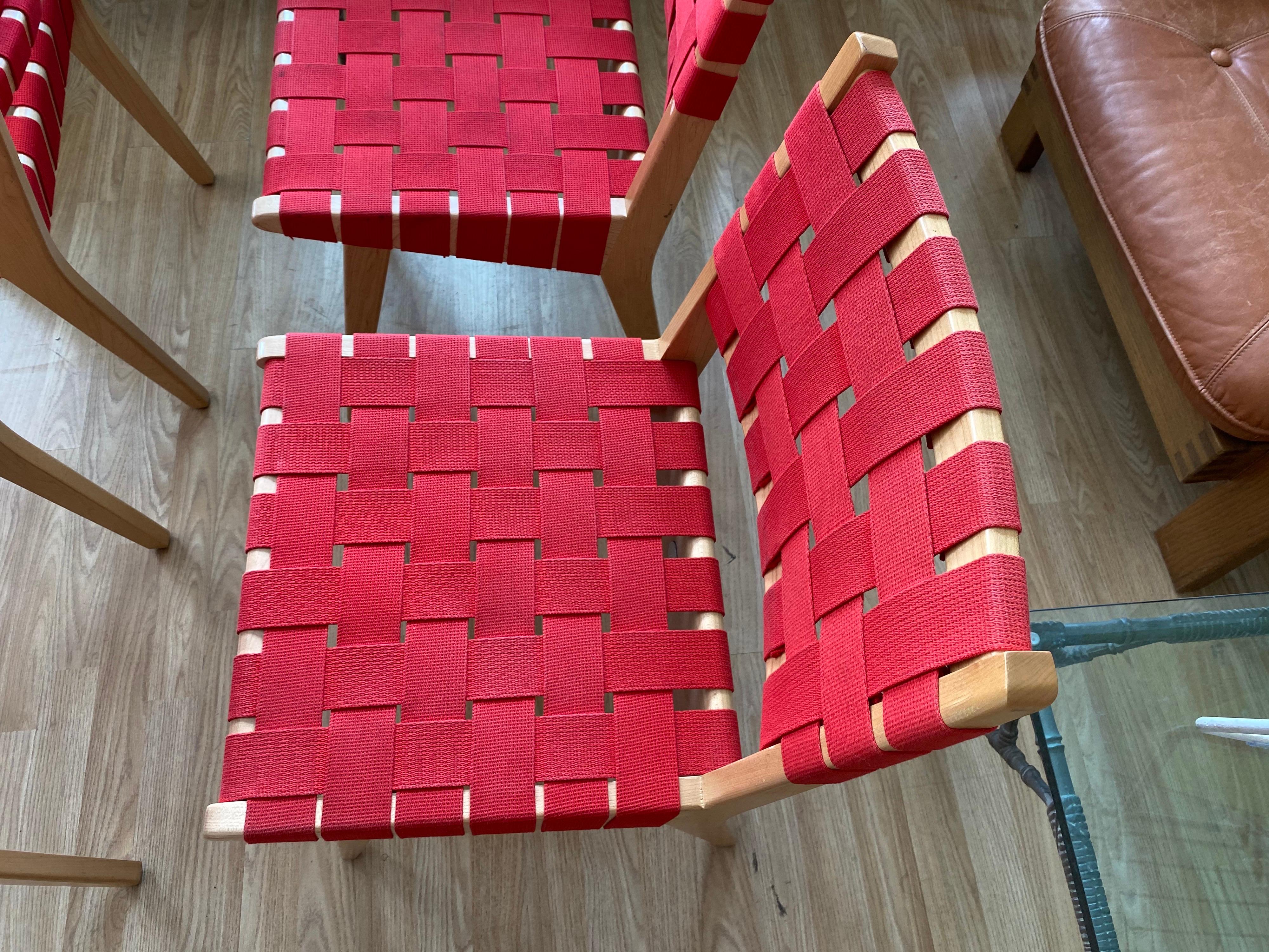 Working within wartime constraints, Risom designed his collection of chairs and tables using simple maple frames, essentially scraps of wood and rejected nylon straps from parachute production. This set of vibrant red 4 dining chairs are in good