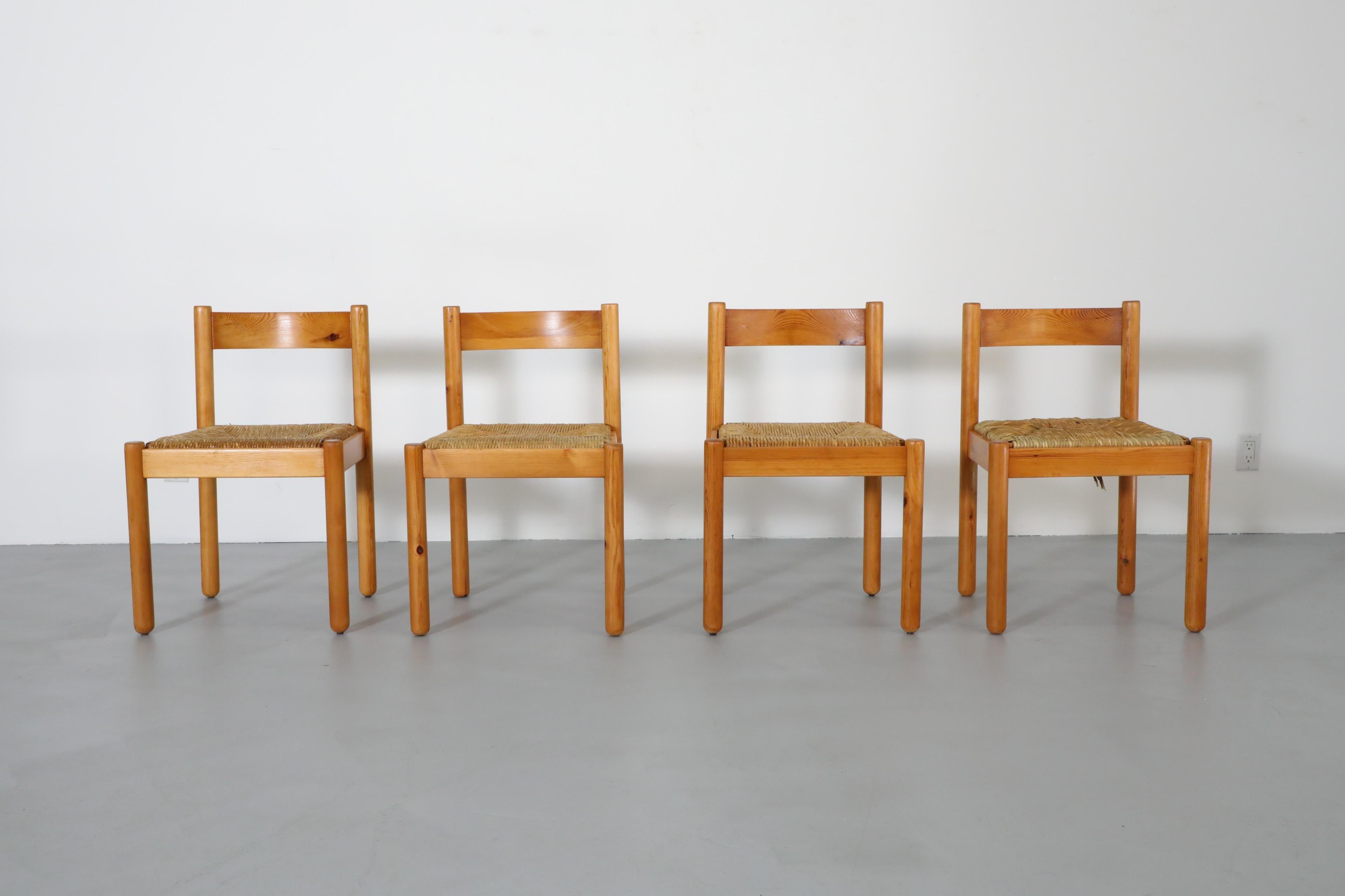 Set di 4 sedie da pranzo in pino in stile Vico Magistretti con sedute in giunco intrecciato e schienale curvo. Bellissimo legno di pino con gambe rotonde e una leggera patina. In condizioni originali, con un'usura visibile della montatura e una