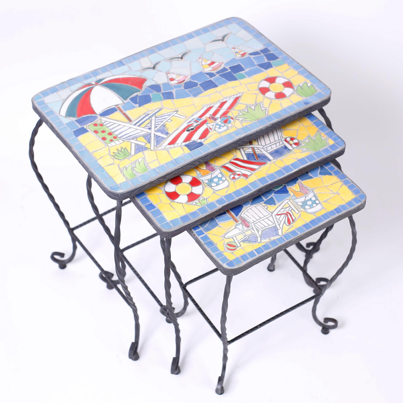 Nest of three tables with wrought and twisted iron, cabriole legs and featuring happy mosaic tile summer scenes with umbrellas, boats, towels and drinks.