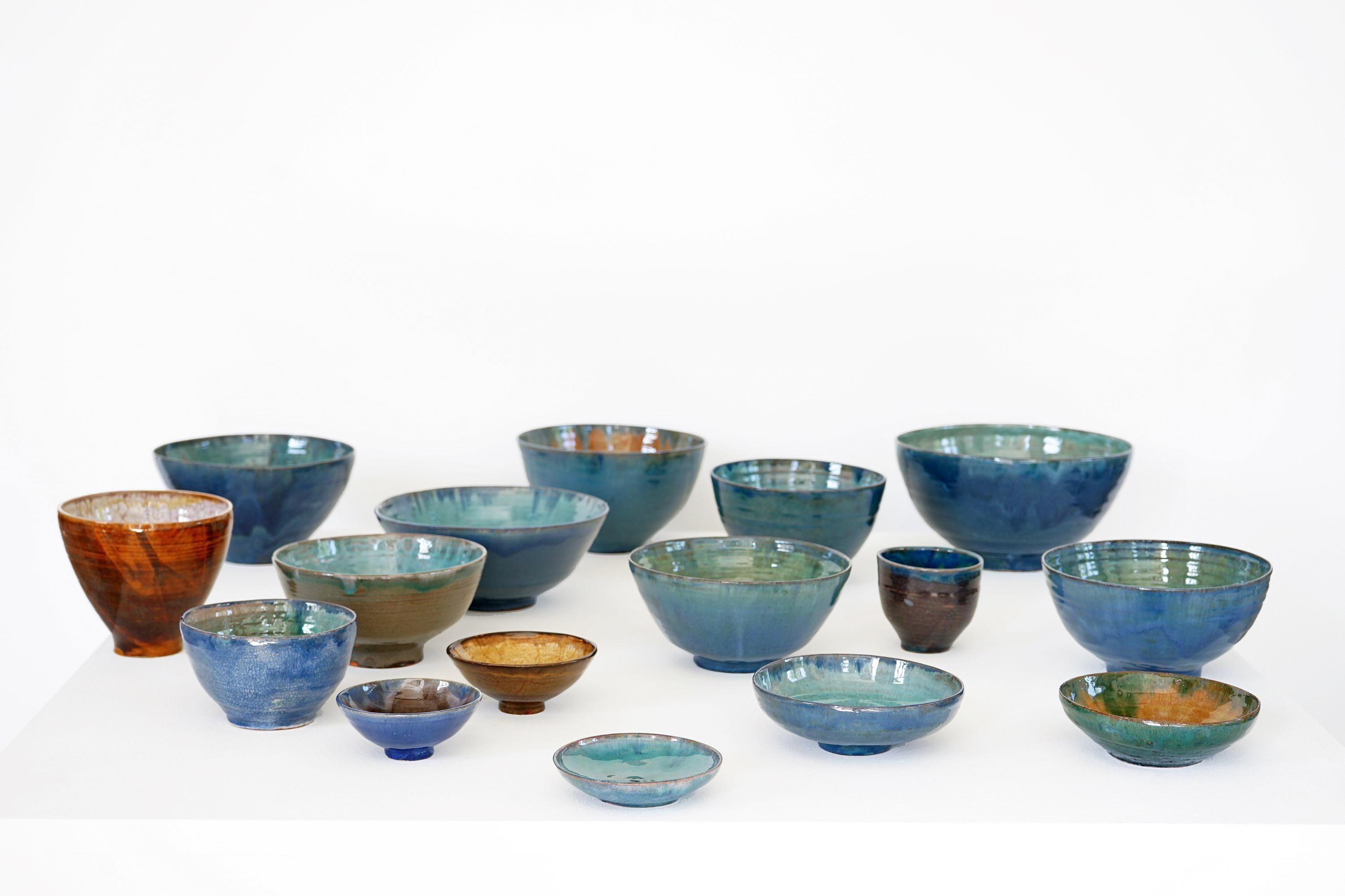 This beautiful set of handmade ceramics consists of 16 bowls, all of which differ in size and color. Since they come from the same artist but different painting techniques were used, an exceptionally beautiful combination of colors and patterns was