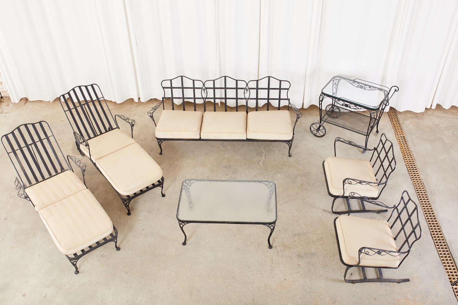 Grand Mid-Century Modern seven piece garden patio lounge set consisting of two adjustable chaise lounges with wheels, two rocking lounge chairs, one 3 seat settee, one 2 tier rolling bar cart, and one glass top cocktail table. Beautifully crafted