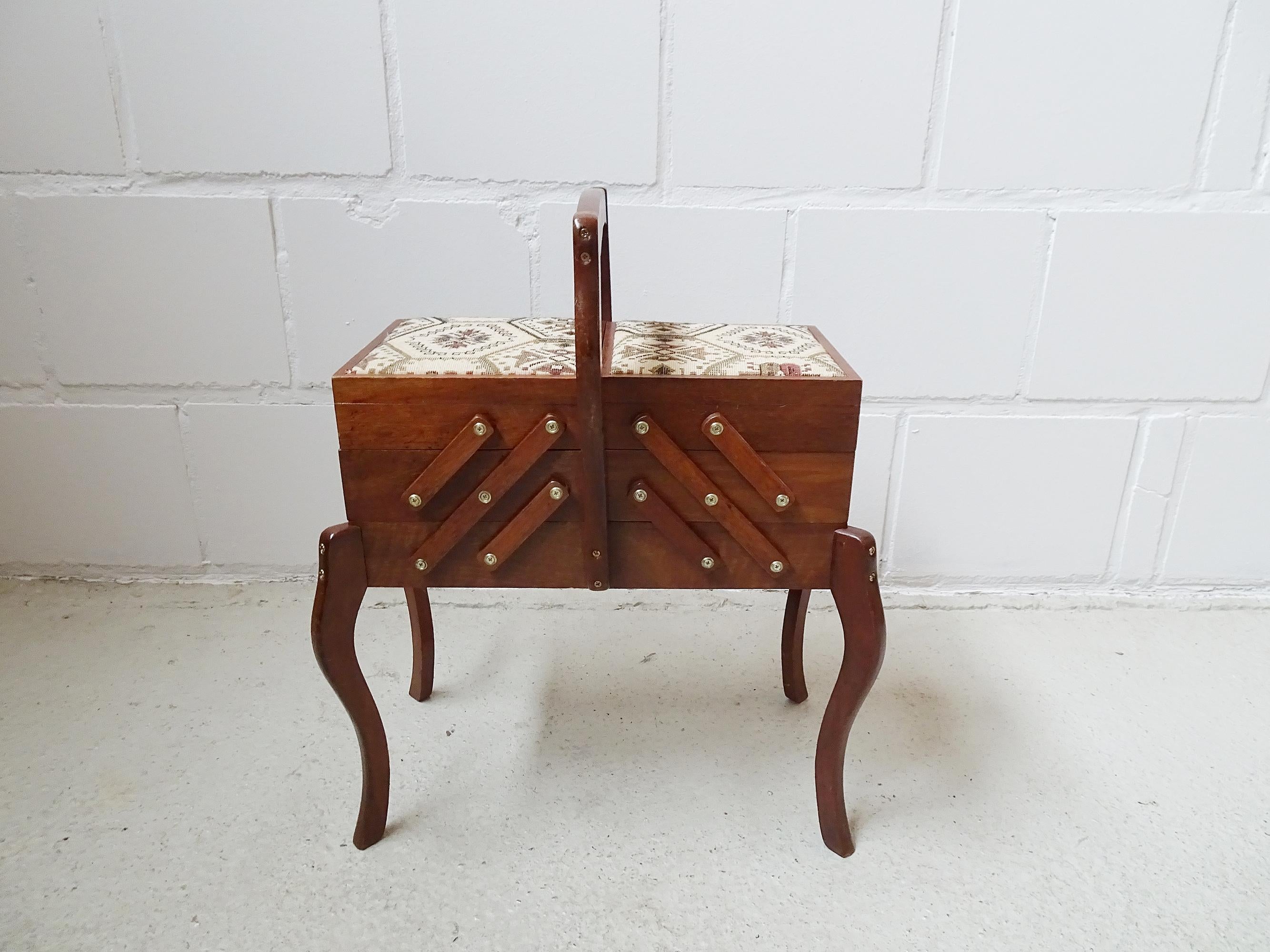 Filigree sewing table from the 1950s. The mix of Boho and Chippendale makes this small and very spacious sewing box the perfect companion for handicrafts with exhibition character. Wooden body with curved legs and carrying handle with two