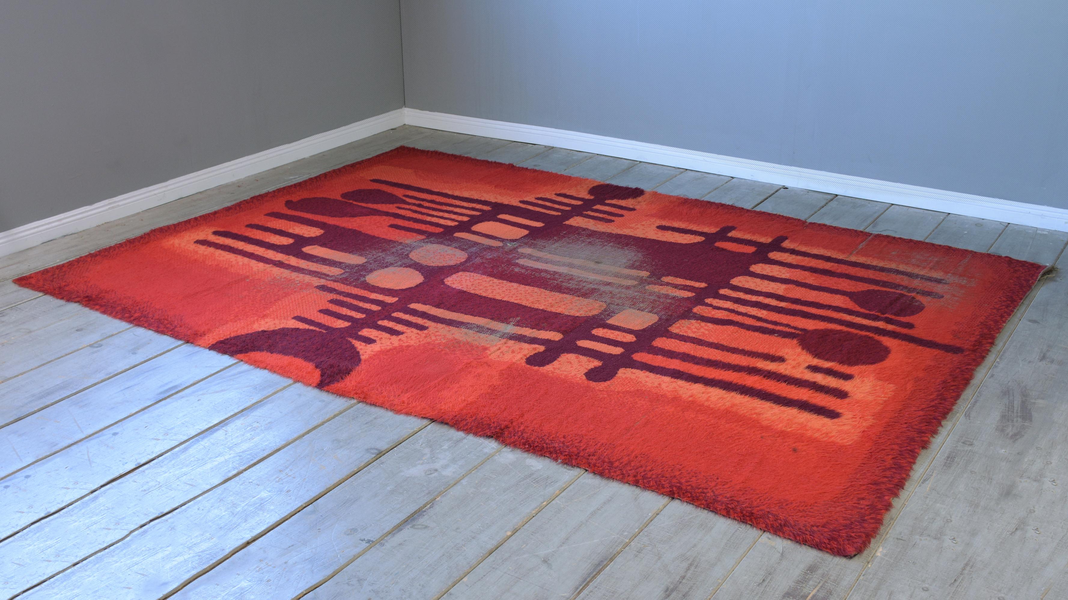 This vibrant Scandinavian fire pattern shag rug by Ege Rya has a thick wool pile, with vibrant colors in red, orange, pink, and brown colors. This vintage large carpet is sure to add some welcomed color to any inspired sophisticated home decor for