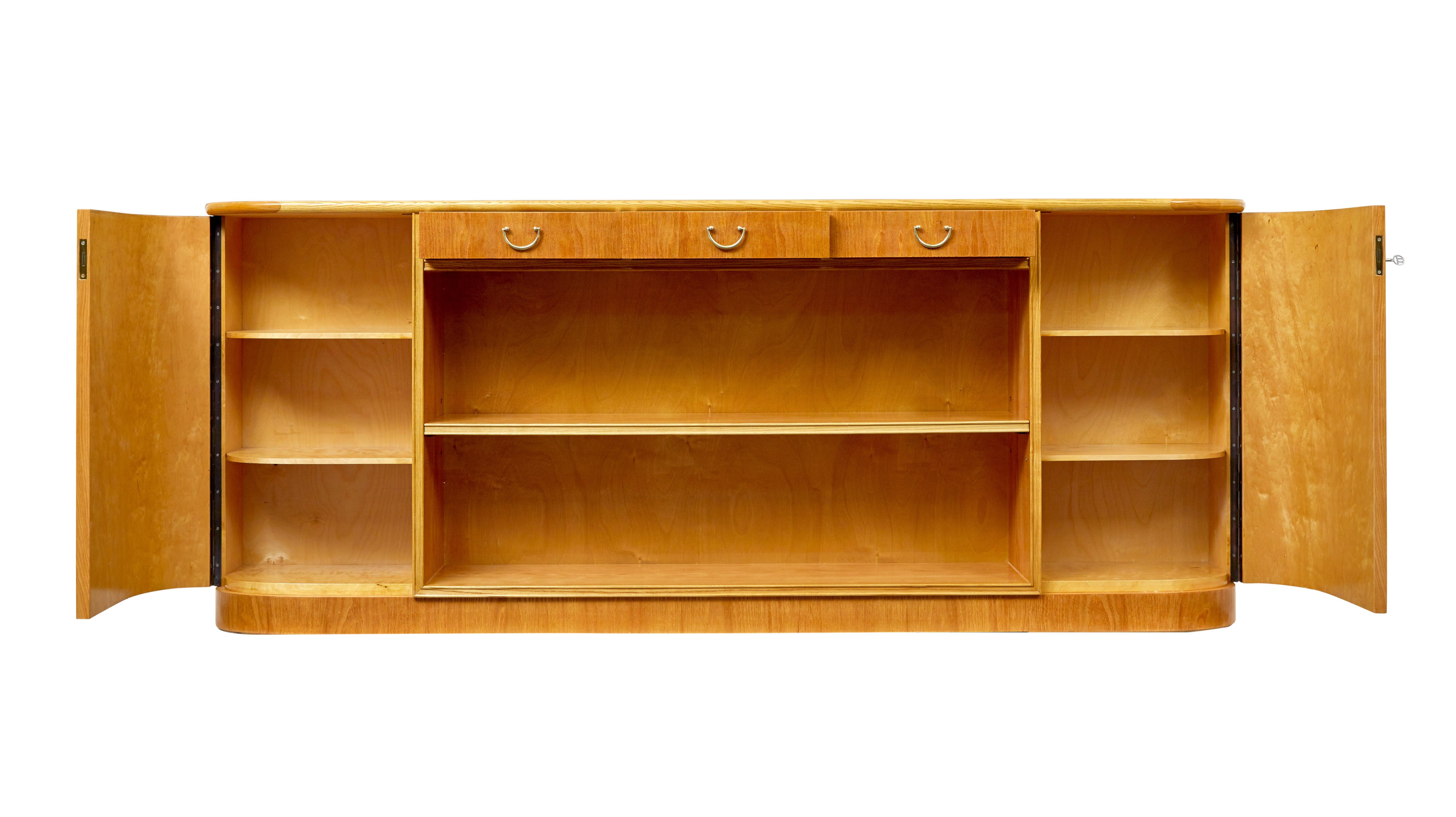 Mid century Scandinavian elm low open bookcase circa 1950.

Stunning piece of Swedish design and woodwork and presented in excellent condition.

At nearly 6 and a half long this shaped end bookcase/cupboard offers a lot of solutions for storage in a