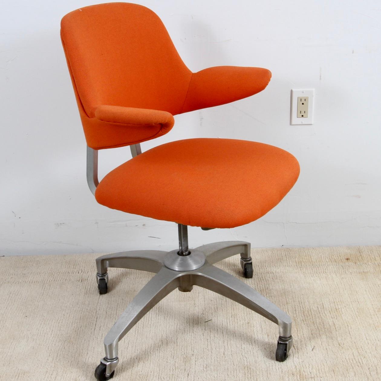 Mid century desk chair with rubber wheels freshly recovered in orange fabric. Well made from brushed steel it, has some weight. Seat height can be adjusted. This Shaw-Walker chair will dress up even the coolest MCM desk.