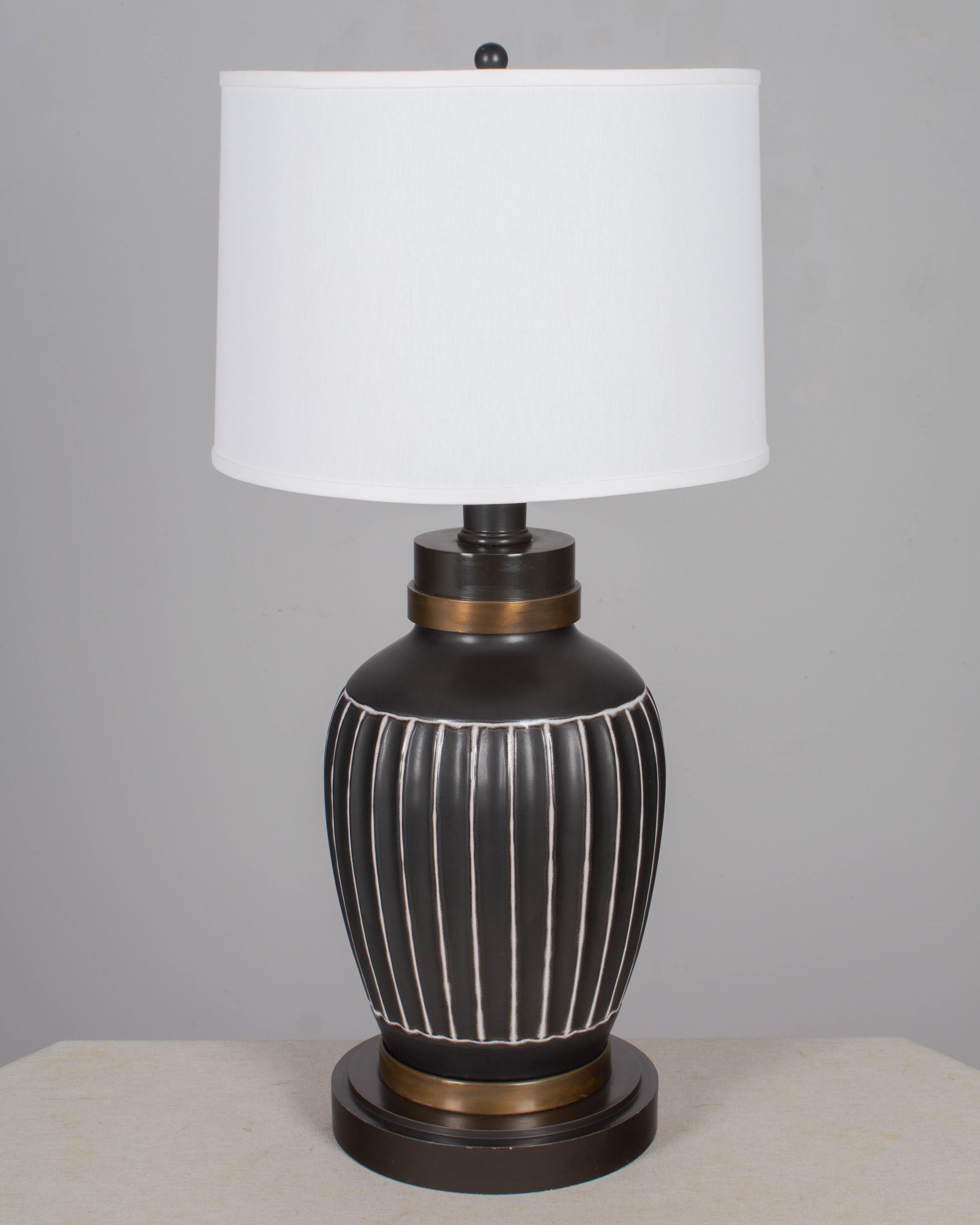 A Danish Mid Century Modern large Soholm black matte ceramic pottery lamp with black painted wood base and brass details. Mark to underside: Soholm Made in Denmark. Rewired with new socket. Shade NOT in included. Circa 1950s. 
Dimensions: 
32