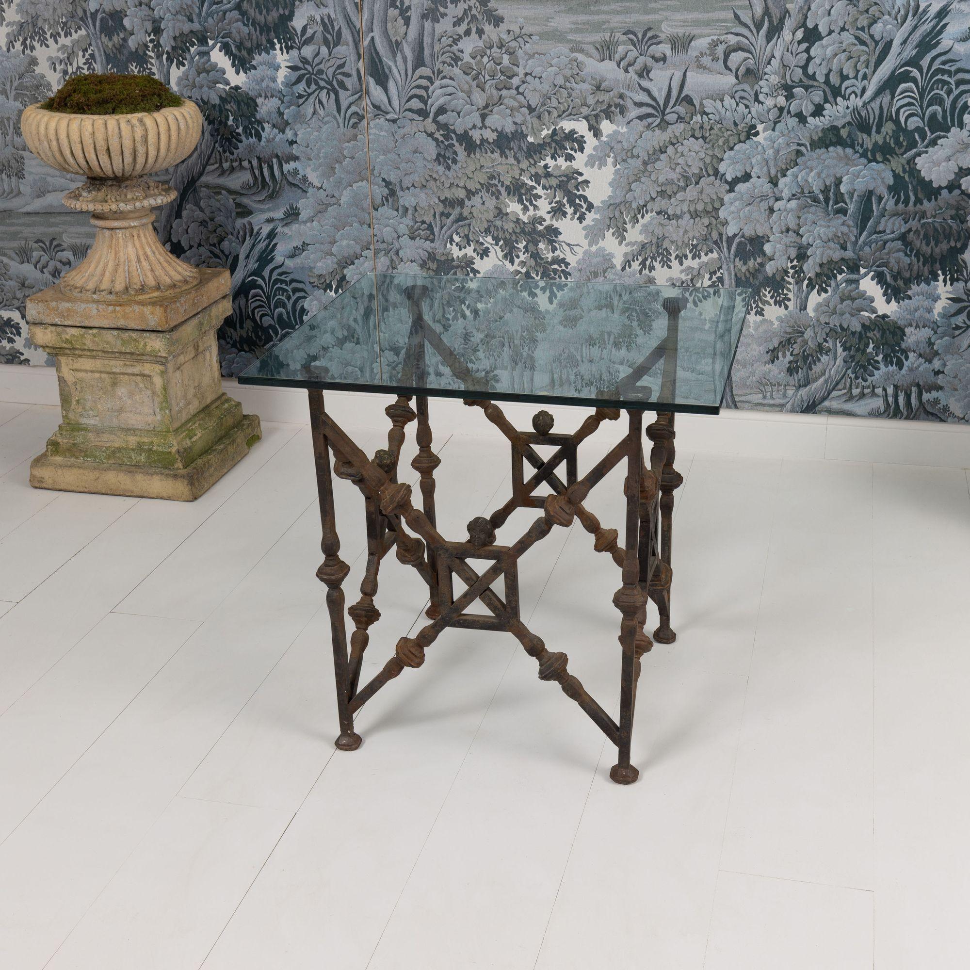 Une belle et rare trouvaille. Table d'appoint italienne en fonte de Sicile avec plateau en verre. Chaque côté comporte quatre têtes de putti en bronze doré. Avec un verre plus grand, cette table ferait une belle table de salle à manger. Circa 1940.