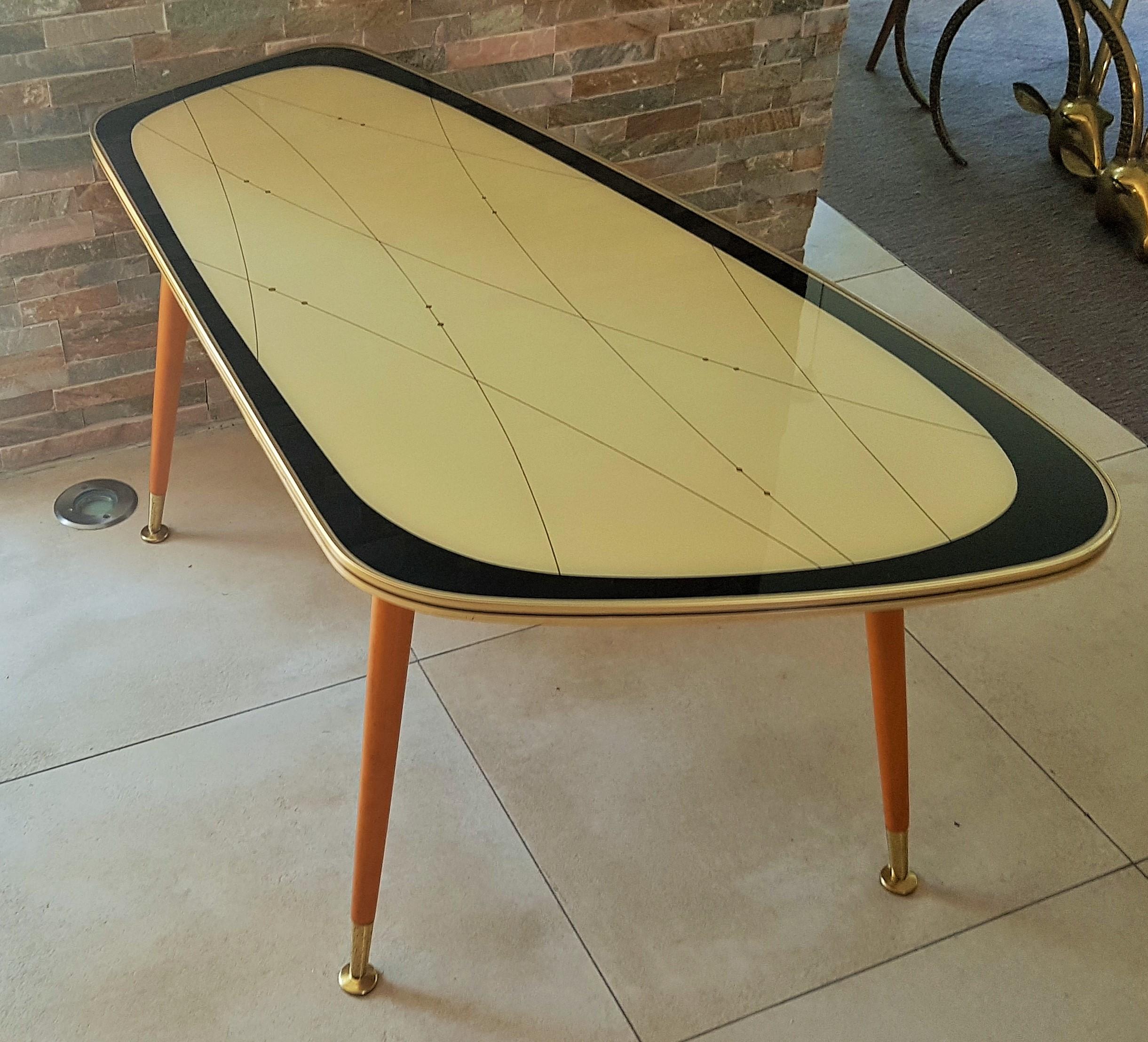 Midcentury side coffee table, Germany 1950s. Black gold Ivory laquer under glass. UFO legs with brass feet.
Very good vintage condition.

    