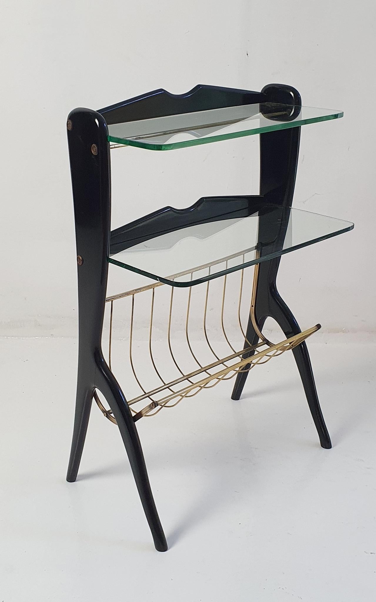 Multi-functional side table by renowned Italian designer Ico Parisi. The sleek side table has a magazine holder as well as having two solid glass shelves. Making it practical and possible to use in various settings. The structure is made from