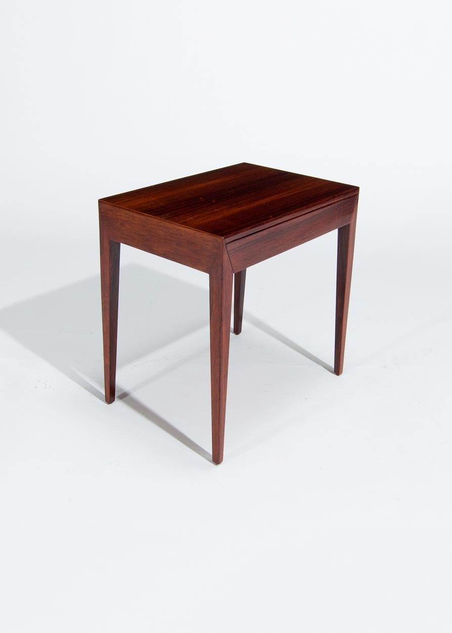 A beautiful mid century side table /  bed side table in rosewood with a single pull out drawer designed by Severin Hansen for Haslev Møbelsnedkeri in the 1960’s. An iconic design by Severin Hansen as with the dining table we are selling it has the