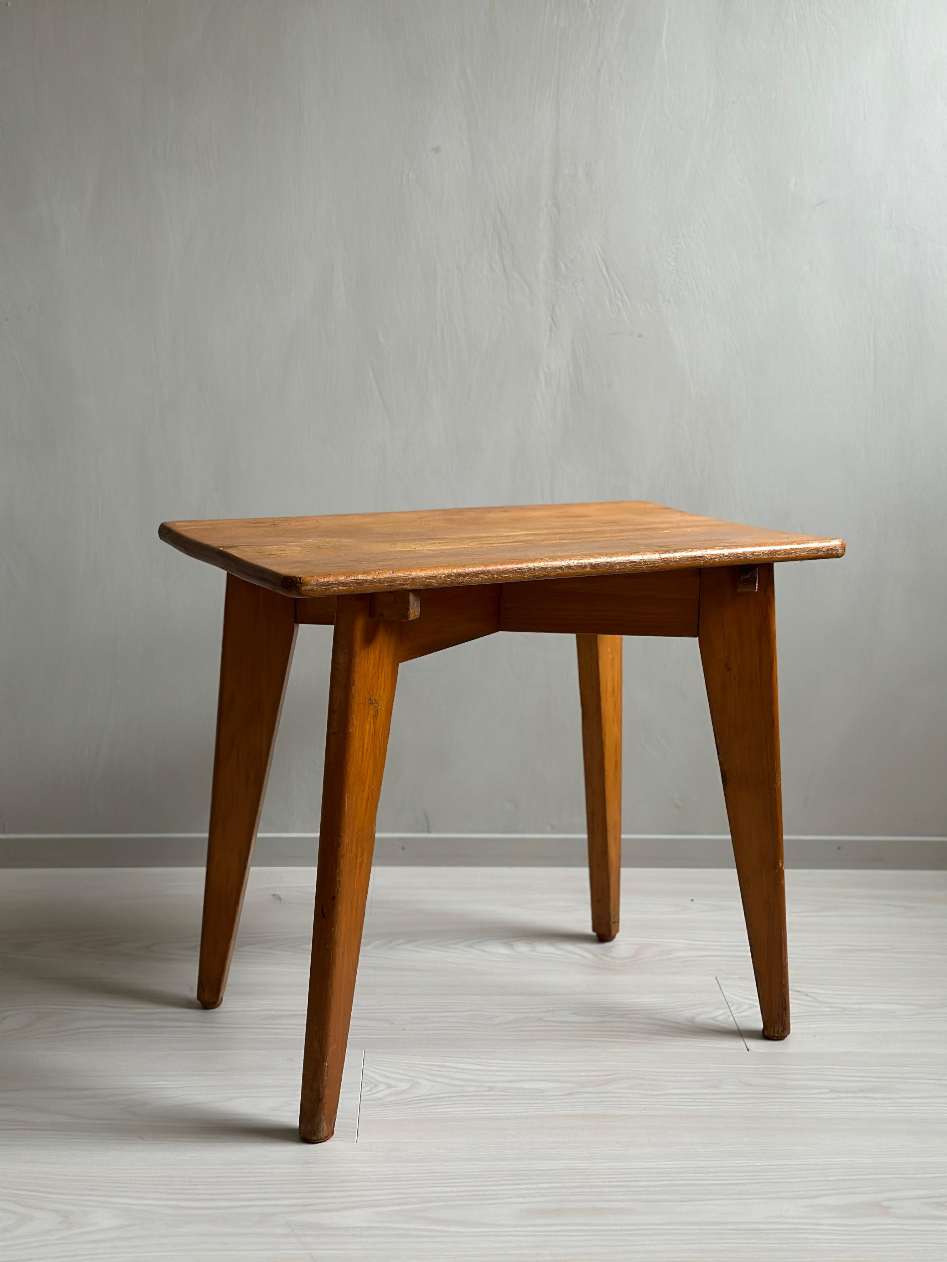 This beautiful midcentury side table captures the iconic style of Jean Prouvé, a celebrated French furniture designer and architect. Crafted in the 1950s during the French reconstruction era. The table has a lovely patina that gives it a warm and