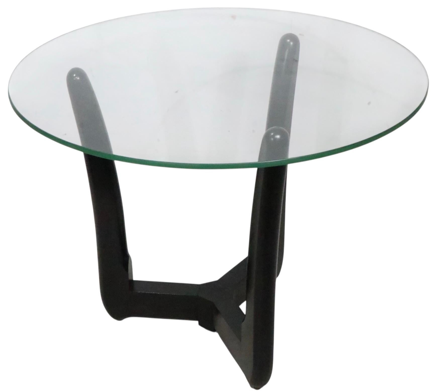 Classic Mid Century Side, or End Table, having a sculptural base of solid wood, in original black paint finish, with its original disk form glass top. The table is in very fine, original claen and ready to use condition, showing only light cosmetic