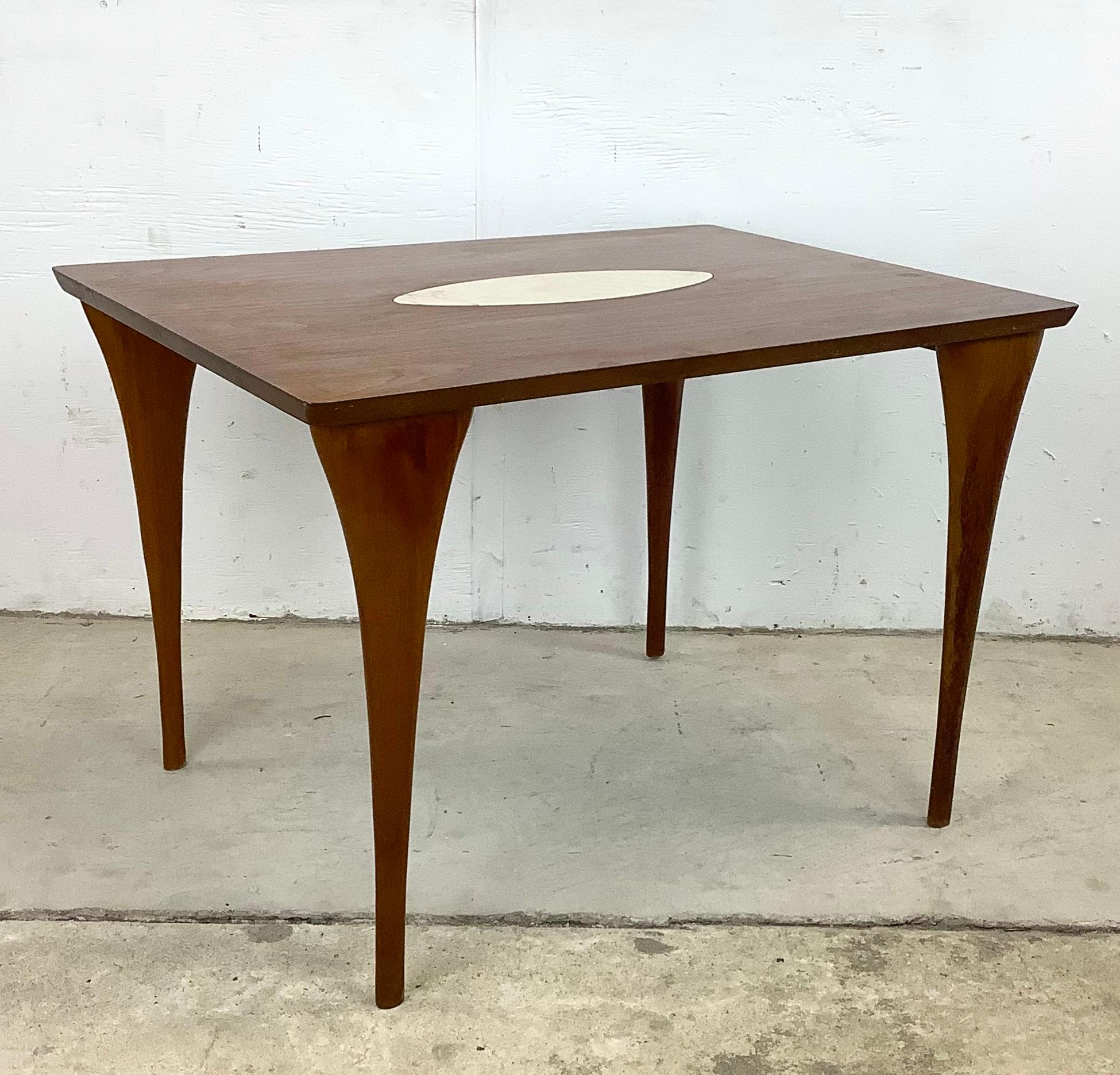 This striking Mid-Century Modern side table was made in Italy and features a beautiful wood finish, sculptural tapered legs, and unique stone inlay- the simple yet elegant appeal of this mid-century end table make it the perfect piece of vintage