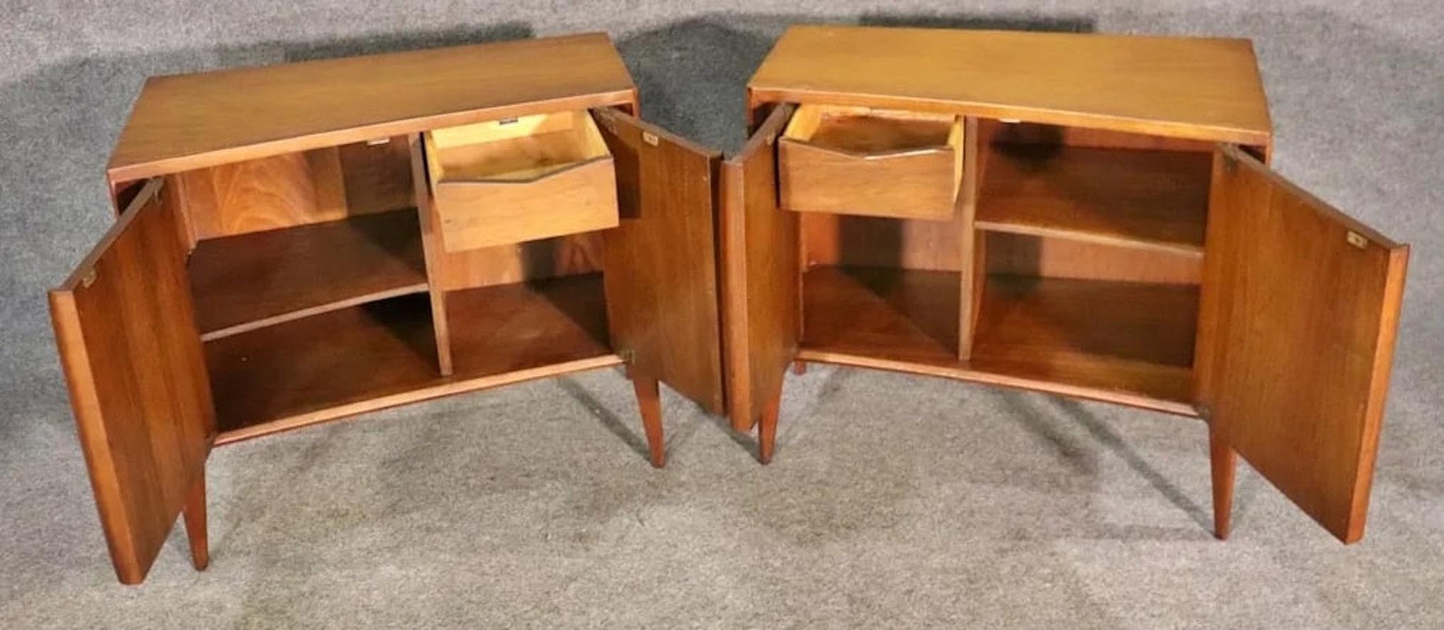 Pair of mid-century end tables with storage by Unagusta. Two doors each with storage compartments, sculpted fronts and tapered legs.
Please confirm location NY or NJ