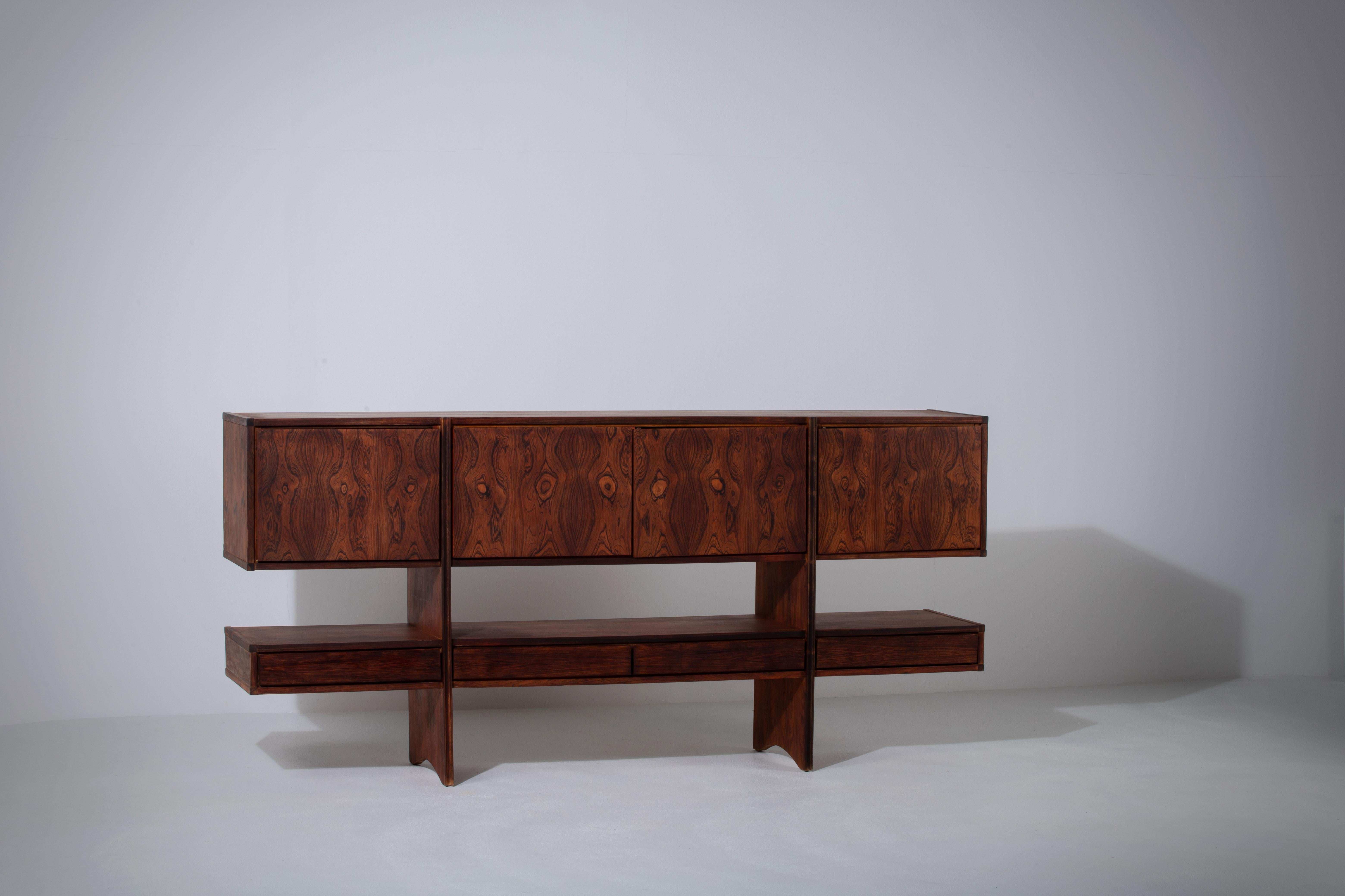 Superb midcentury palisander sideboard. Four drawers and four doors. The sideboard is made of two long sideboards superposed in a full palisander structure.
The integrated handles reinforce the minimalism and the airy aspect of this piece. 
Good