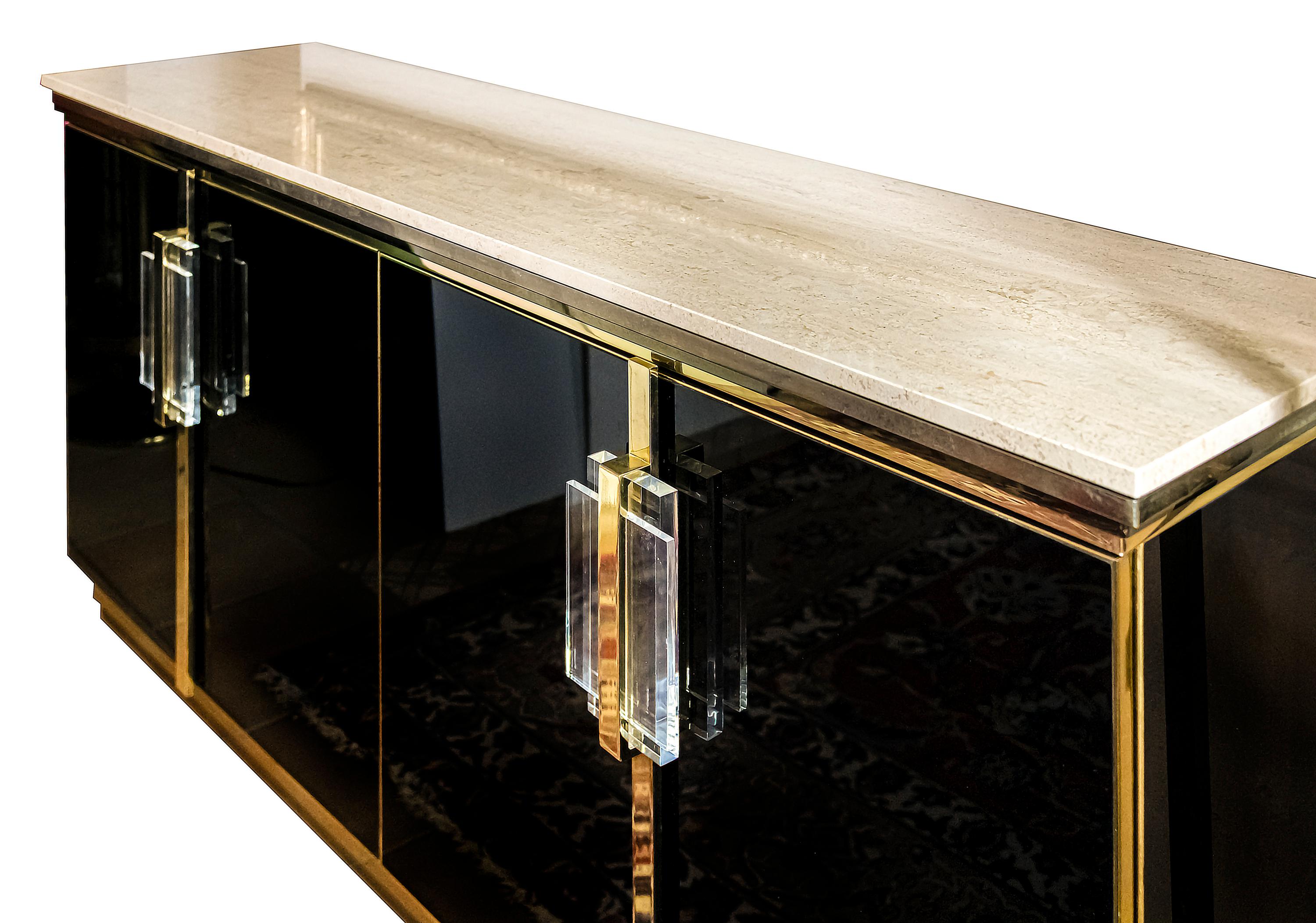 Vintage sideboard / commode from 1970s in the style of Maison Jansen.
Doors are covered with black glass panels and decorated with massive plexiglass handles.
The top is travertine stone.
The pedestal and travertine base are created in brass