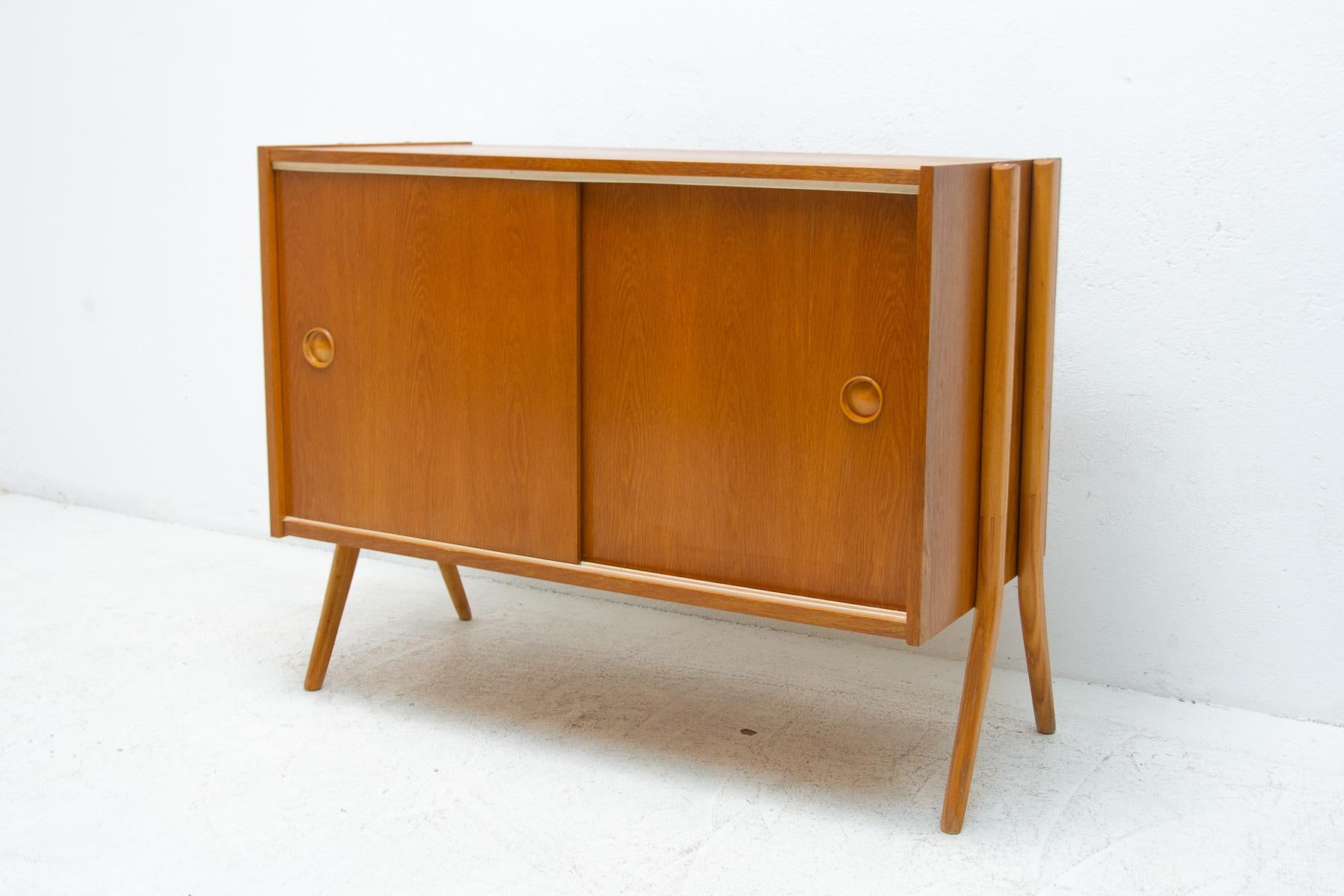 Mid century sideboard or chest of drawers. It features a sliding doors. It´s made of wood and plywood, veneered in a polished beech wood. It was produced by Zapadoslovenske Nabytkarske Zavody, a furniture company in Czechoslovakia in 1970´s. In very