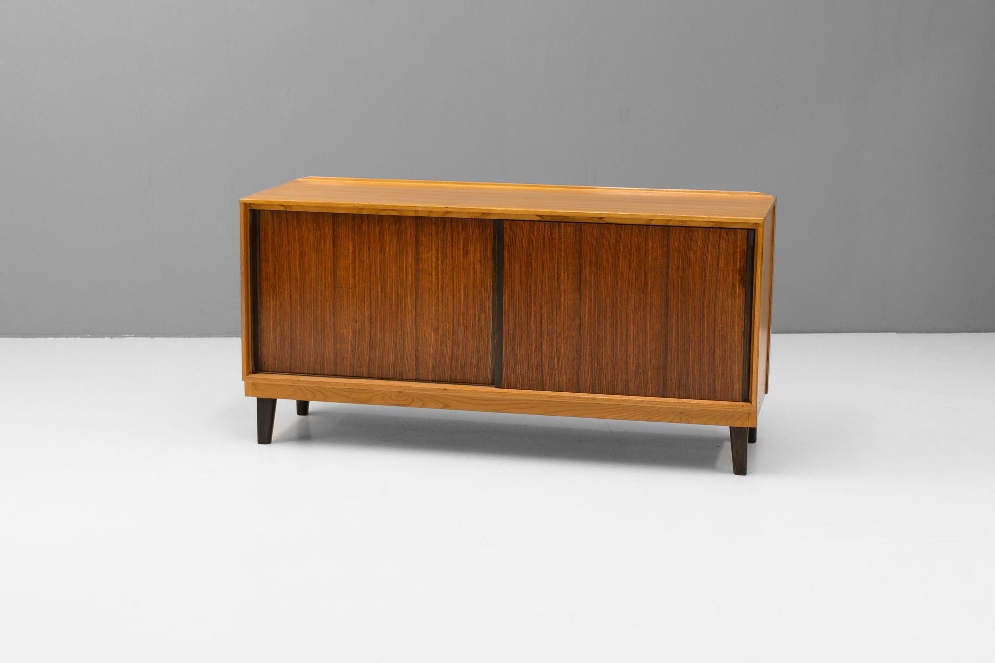 Petit buffet du milieu du siècle par Gordon Russell. Cadre et pieds en chêne massif avec portes en bois de rose et deux étagères intérieures fixes.
K.K. vers 1950.
H 69cm x L 137cm x P 46cm