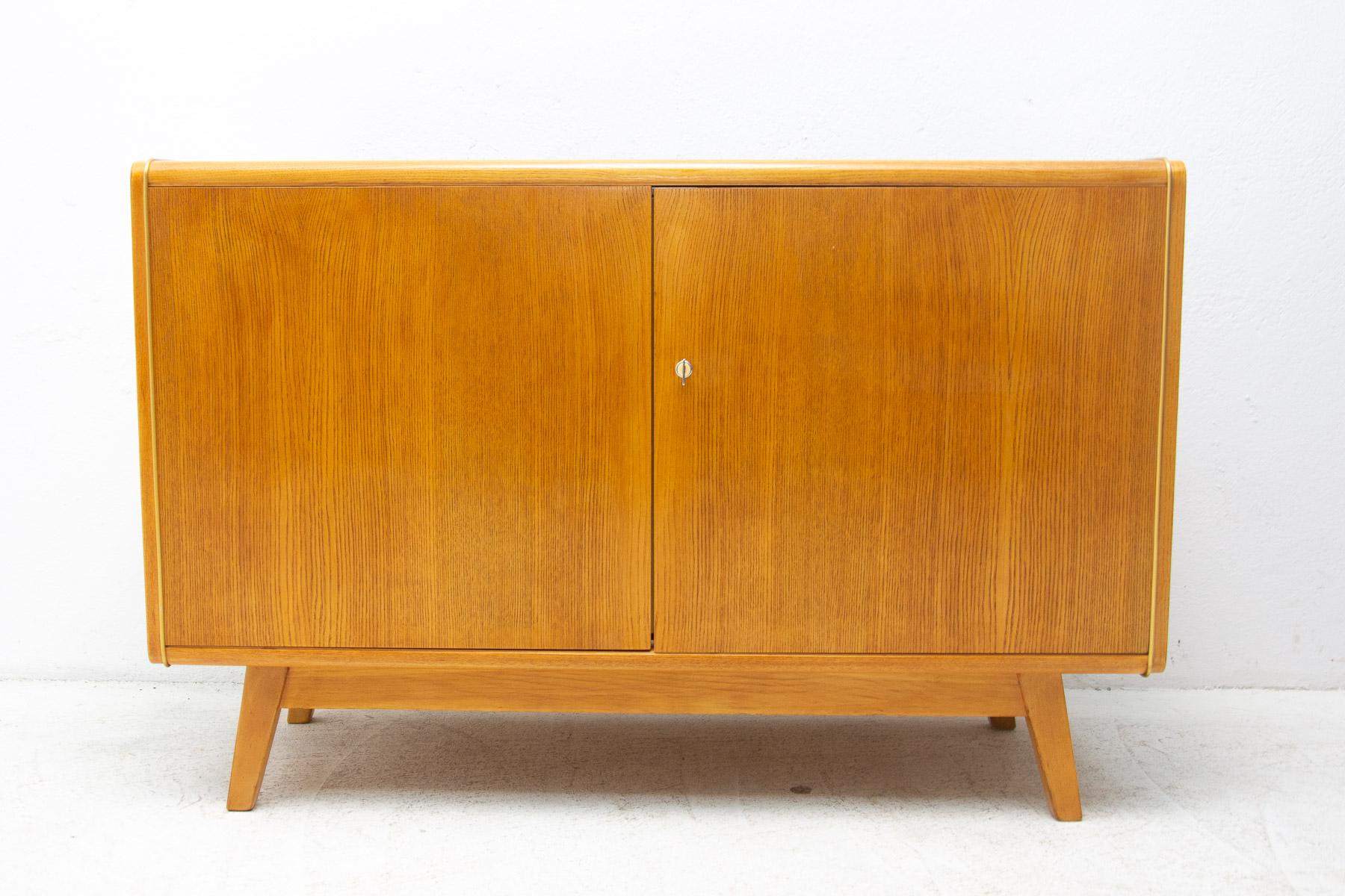 This mid-century sideboard was designed by Hubert Nepožitek & Bohumil Landsman for Jitona company in the 1960´s. Material: beech wood, opaxite glass. In good vintage condition, showing slight signs of age and using.