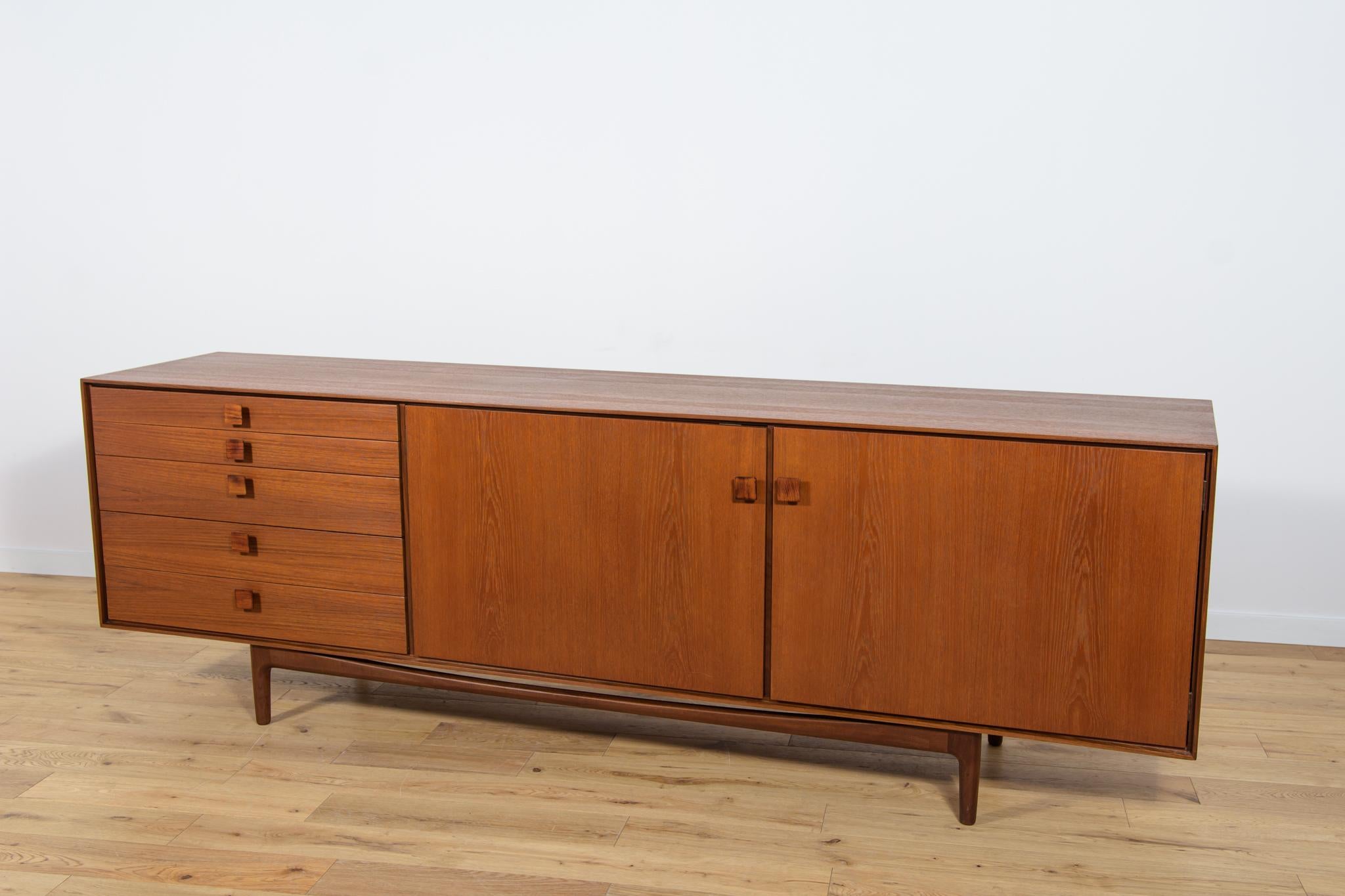 This magnificent mid-century Danish design sideboard credenza was designed by Ib Kofod-Larsen and manufactured by G-Plan circa 1960. It is made of African teak, handles made of rosewood. Features two doors as well as five drawers. Completely